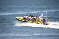 A yellow boat carries passengers across water.