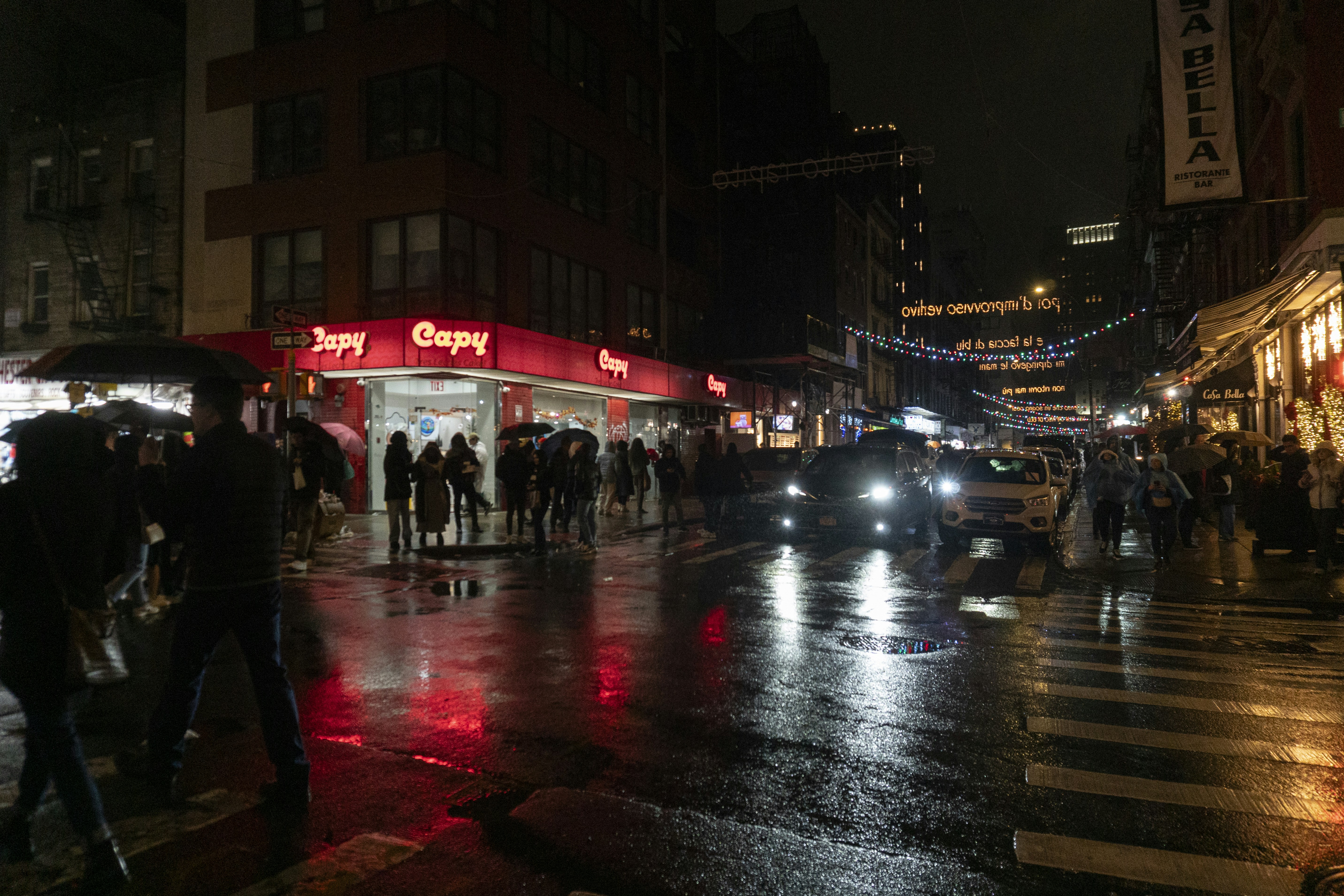 A busy city street reflects lights at night.