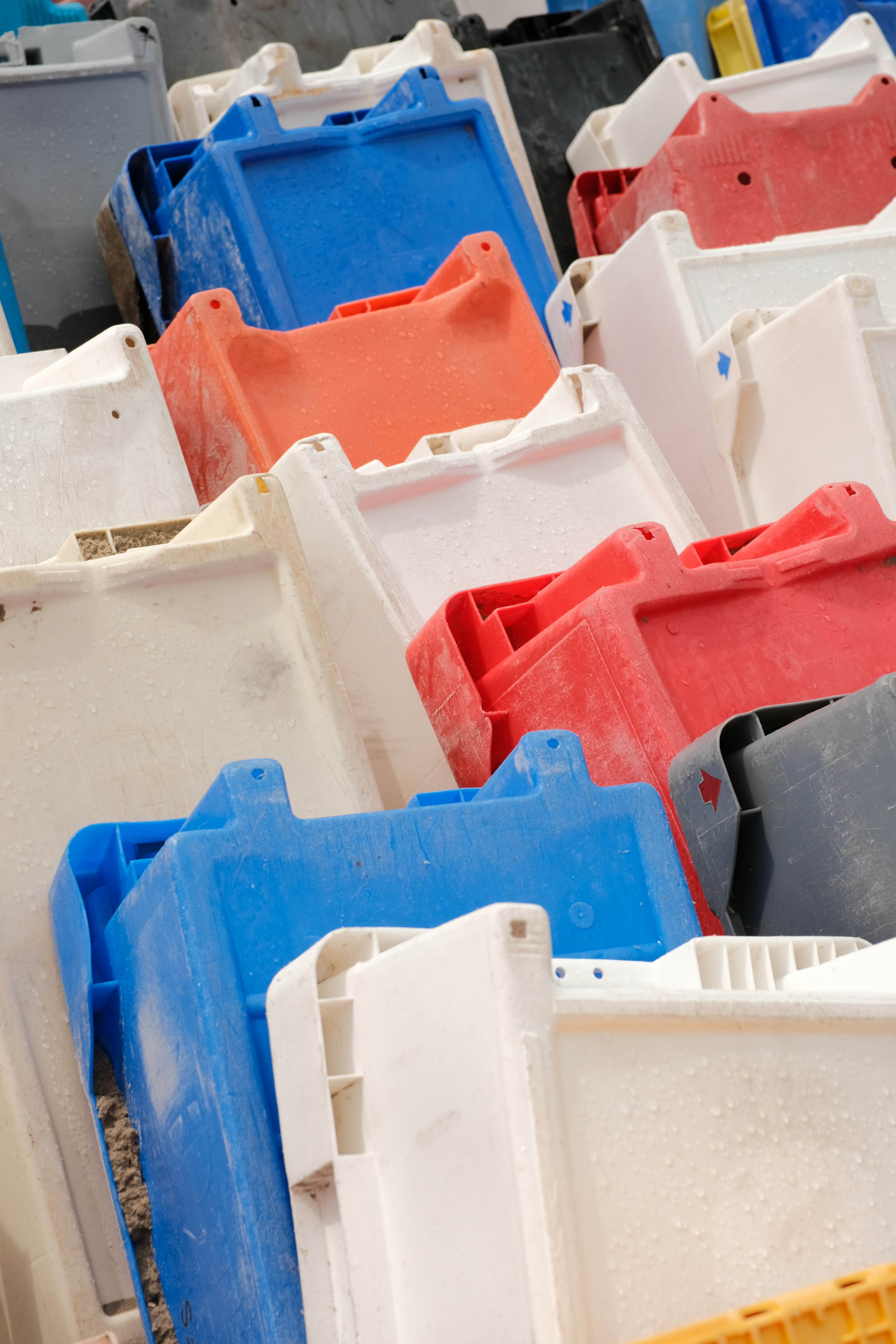 Colorful plastic storage containers are stacked together.