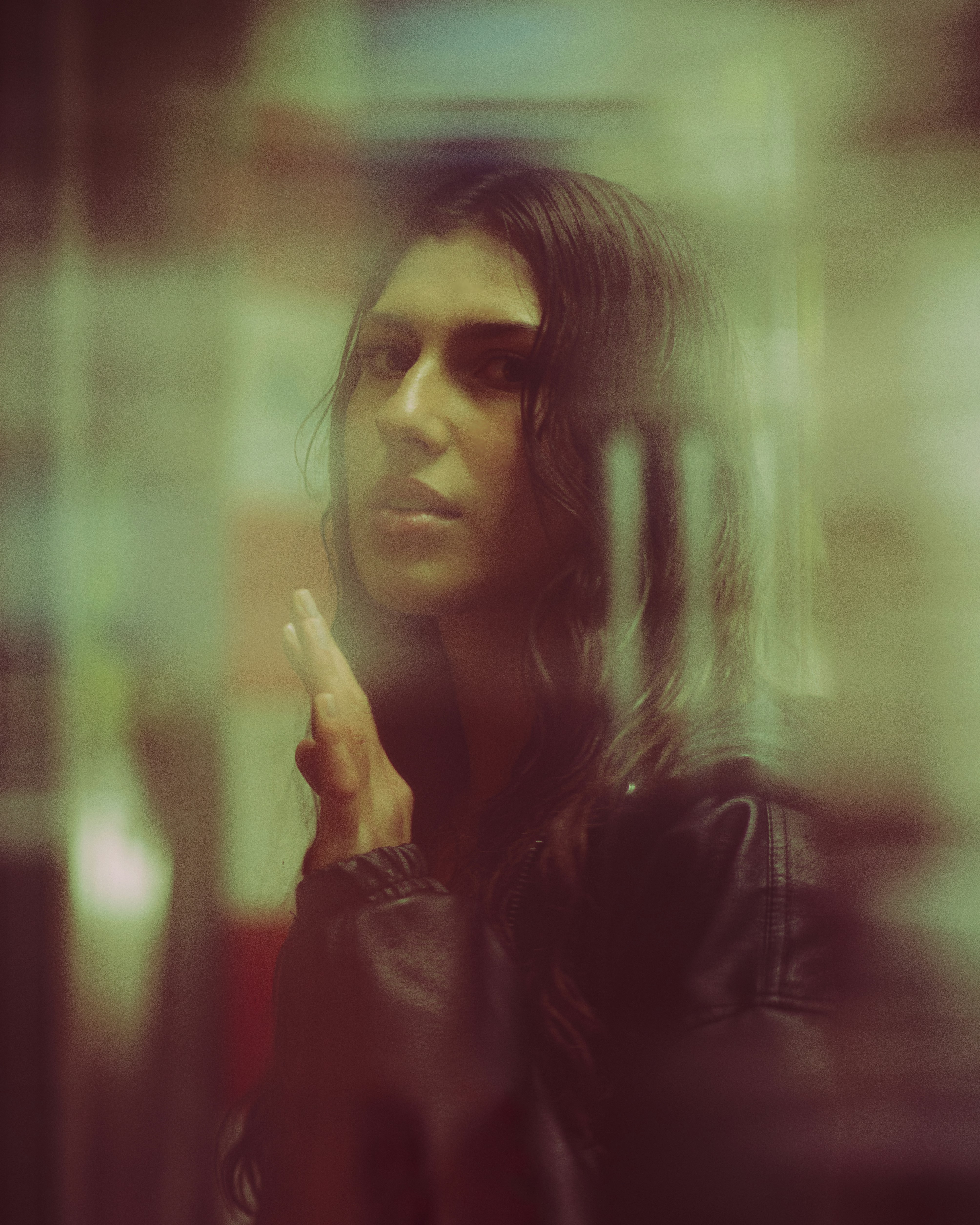 Eine Frau blickt durch ein leicht verschwommenes Fenster.