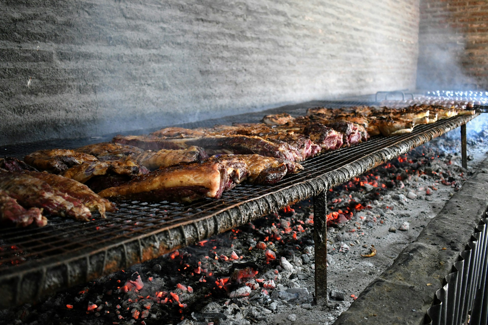 Meat is grilling over hot coals.