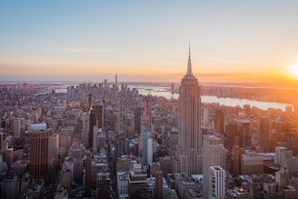 The empire state building shines at sunset in nyc.