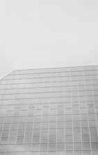A modern glass building in monochrome.