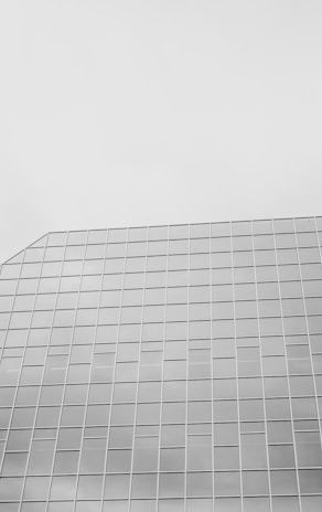 A modern glass building in monochrome.