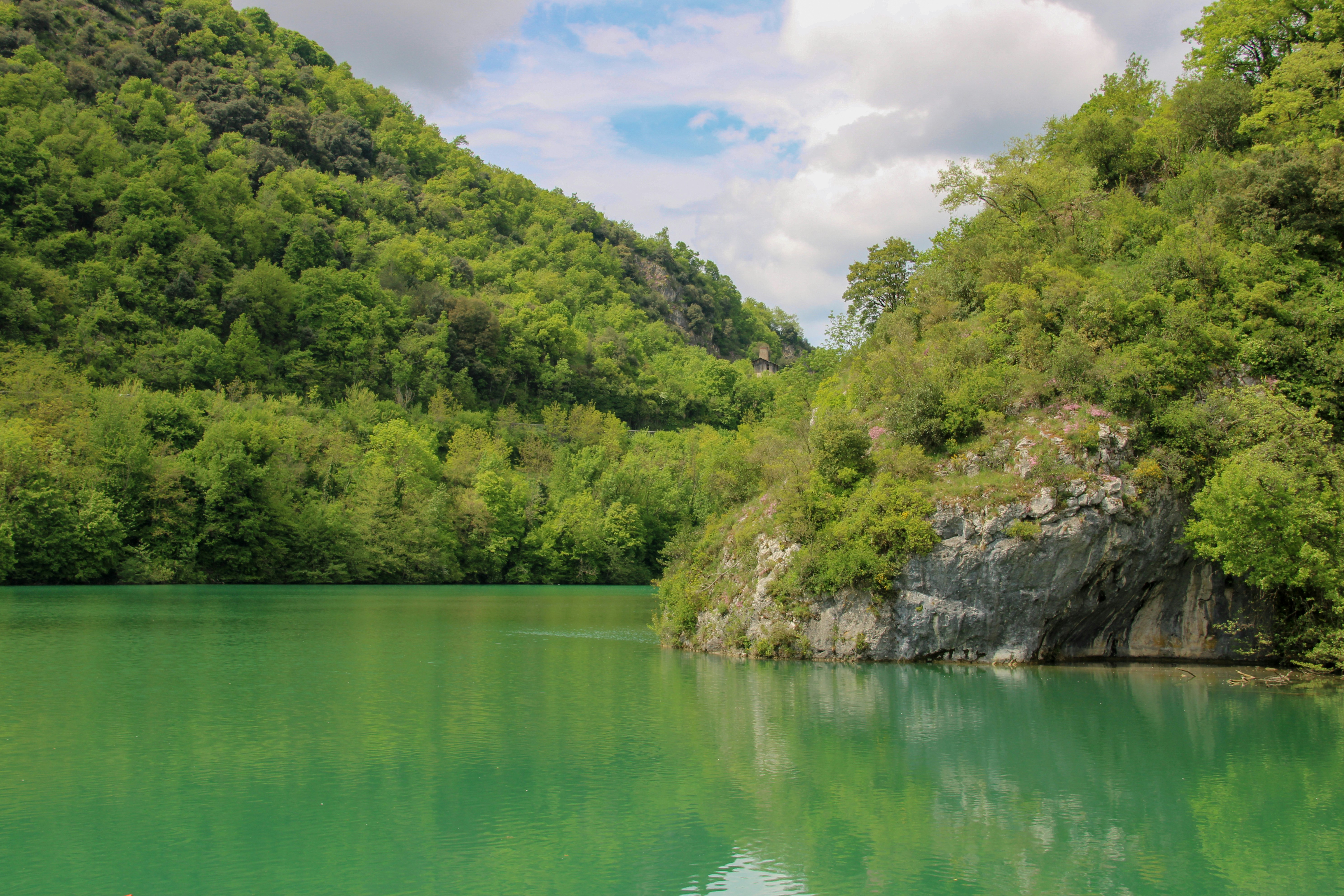 A serene lake reflects the lush green mountains.