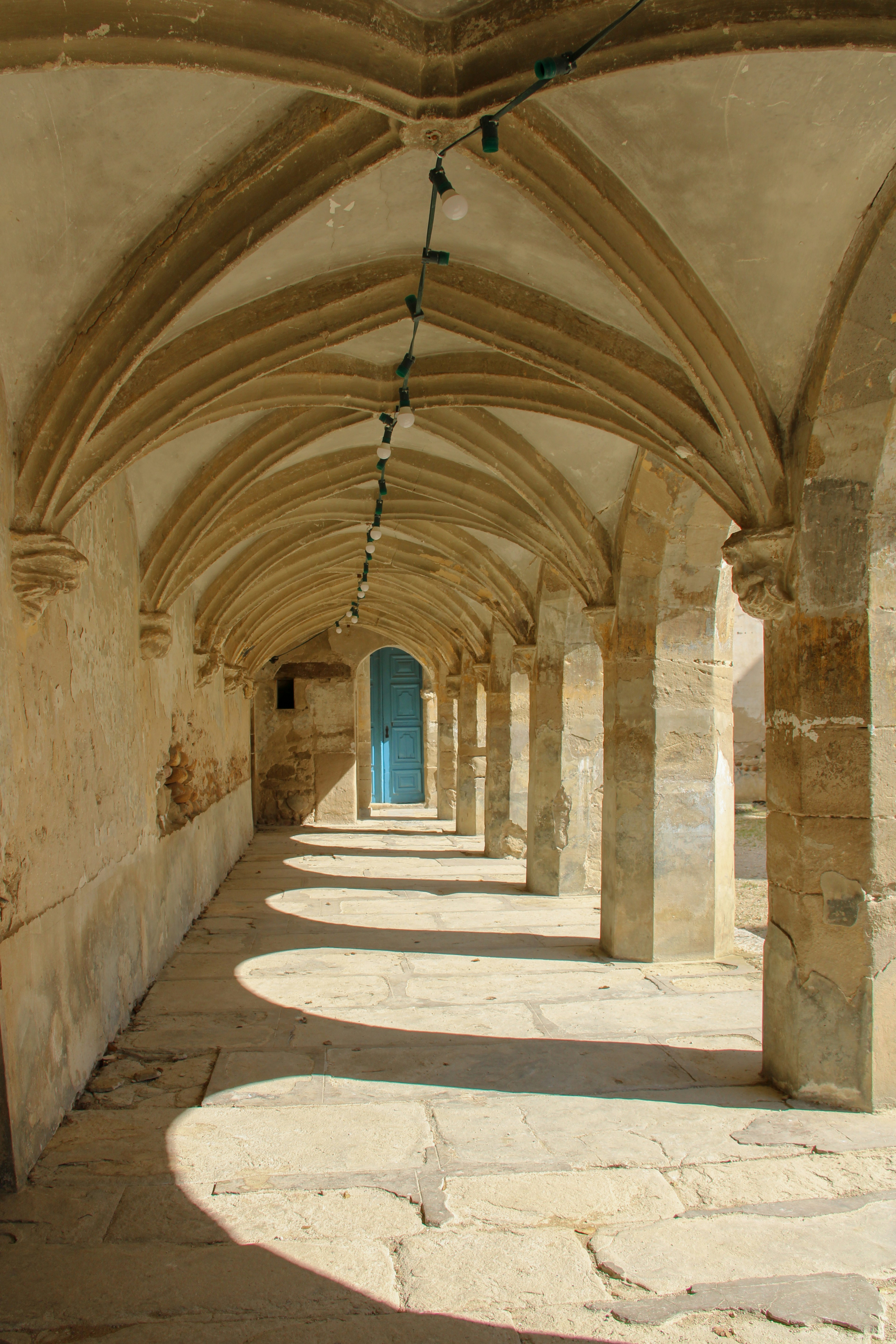 A stone archway leads to a blue door.
