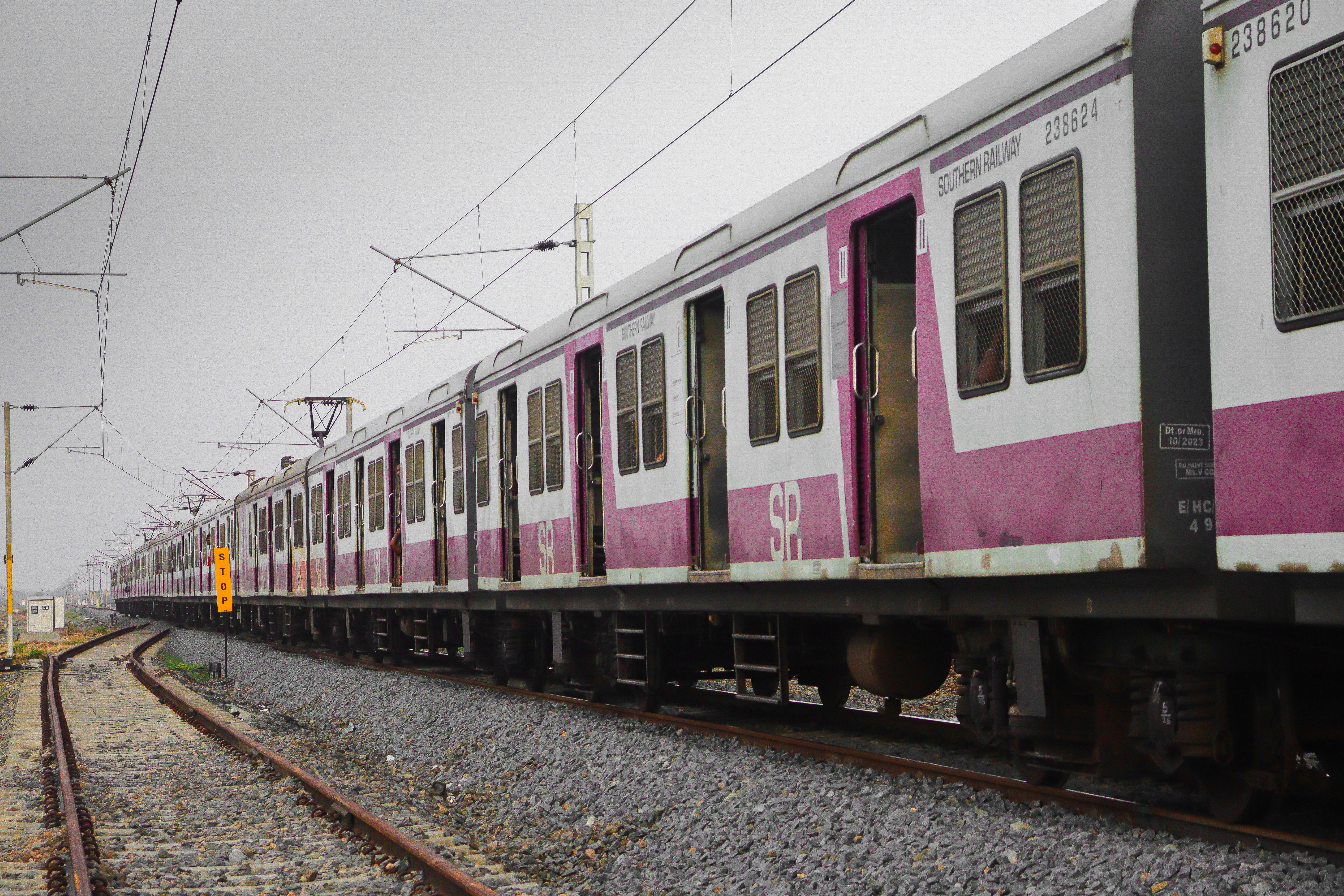 A railway platform with a distinct pink-painted ladies coach, showing a clear 