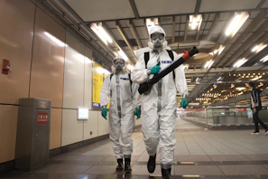Workers in hazmat suits disinfect a subway station.