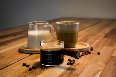 Coffee with cream and beans on a wooden table