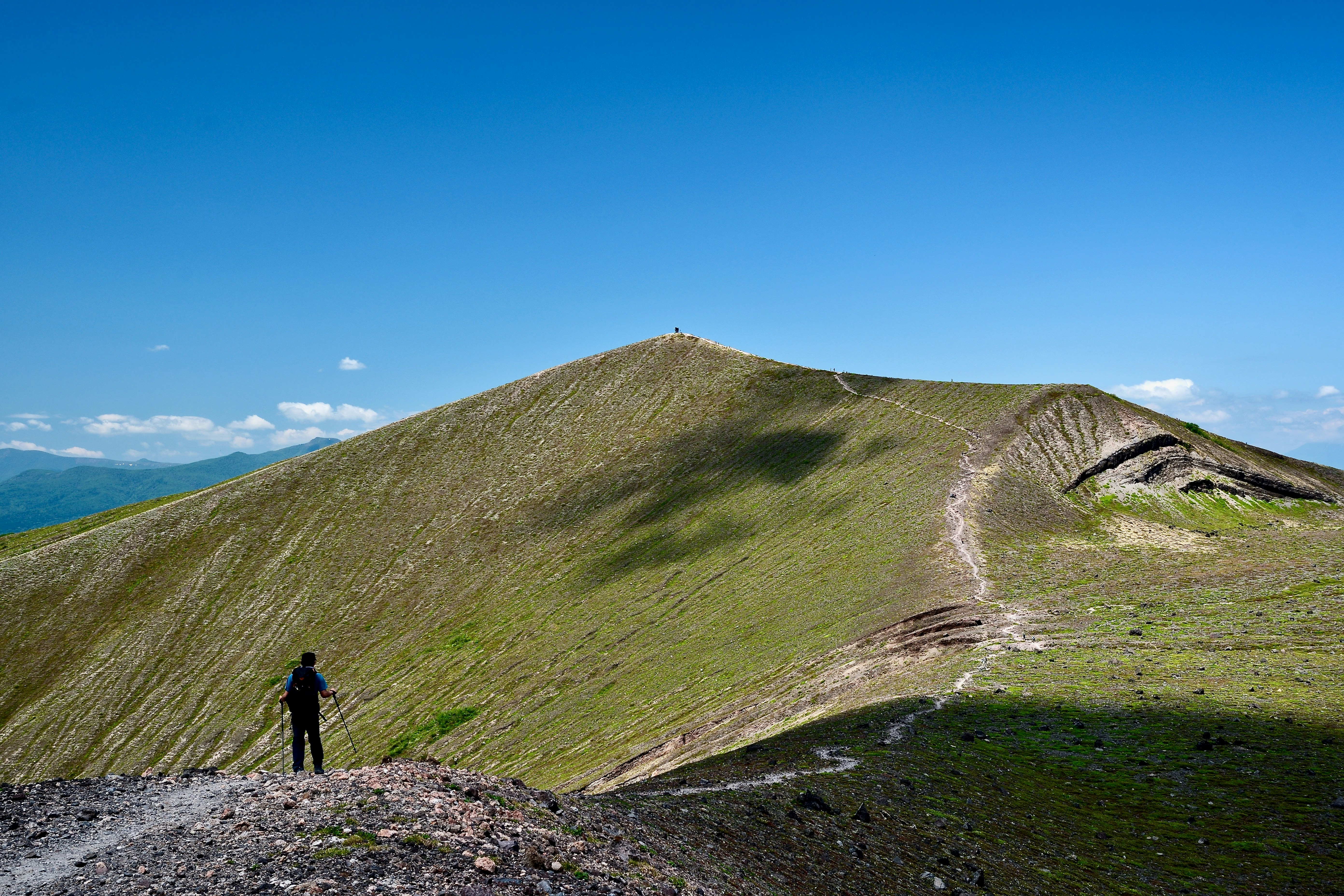A hiker contemplates a mountain's summit.