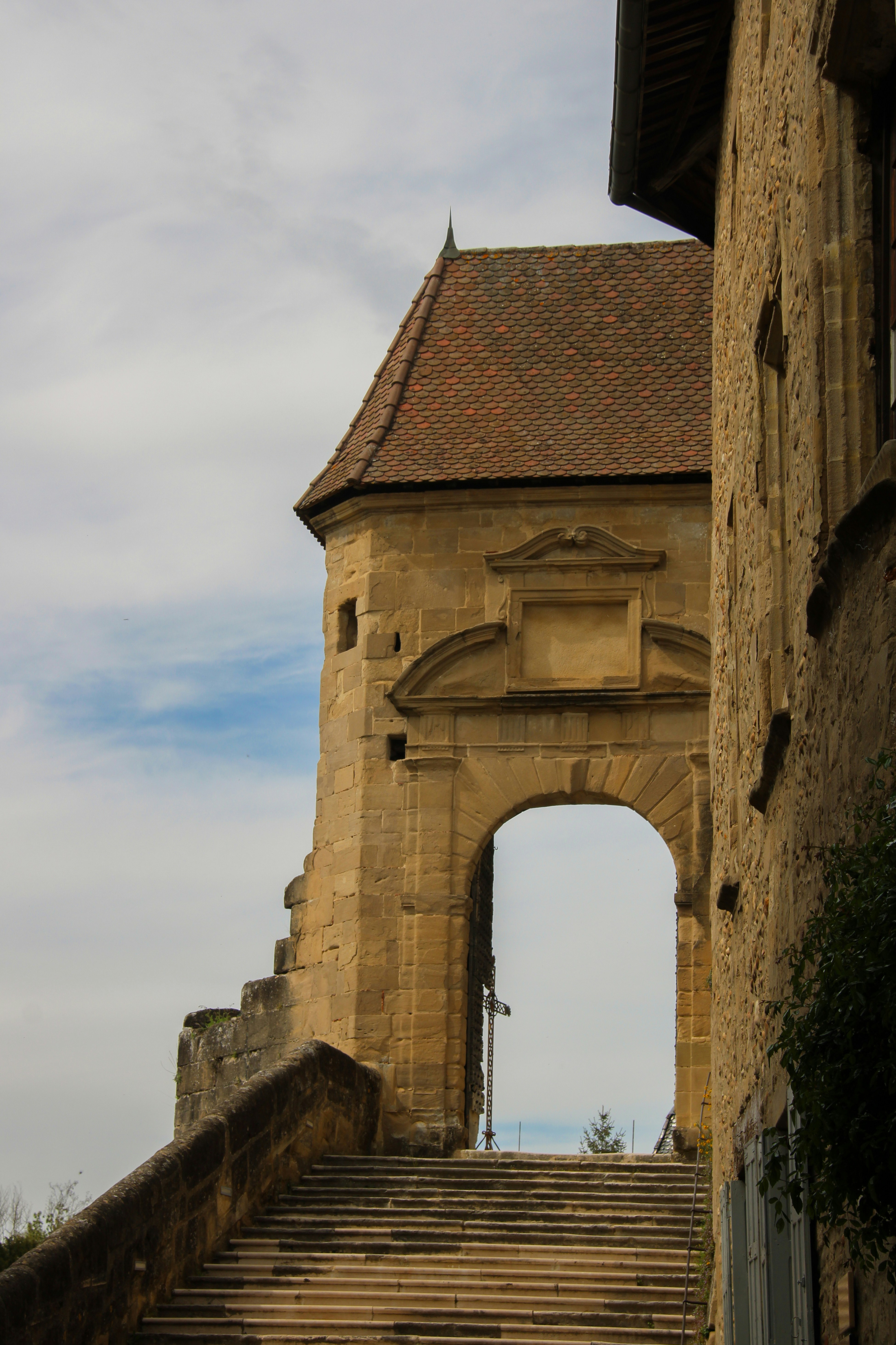 An arched doorway sits above stone steps.