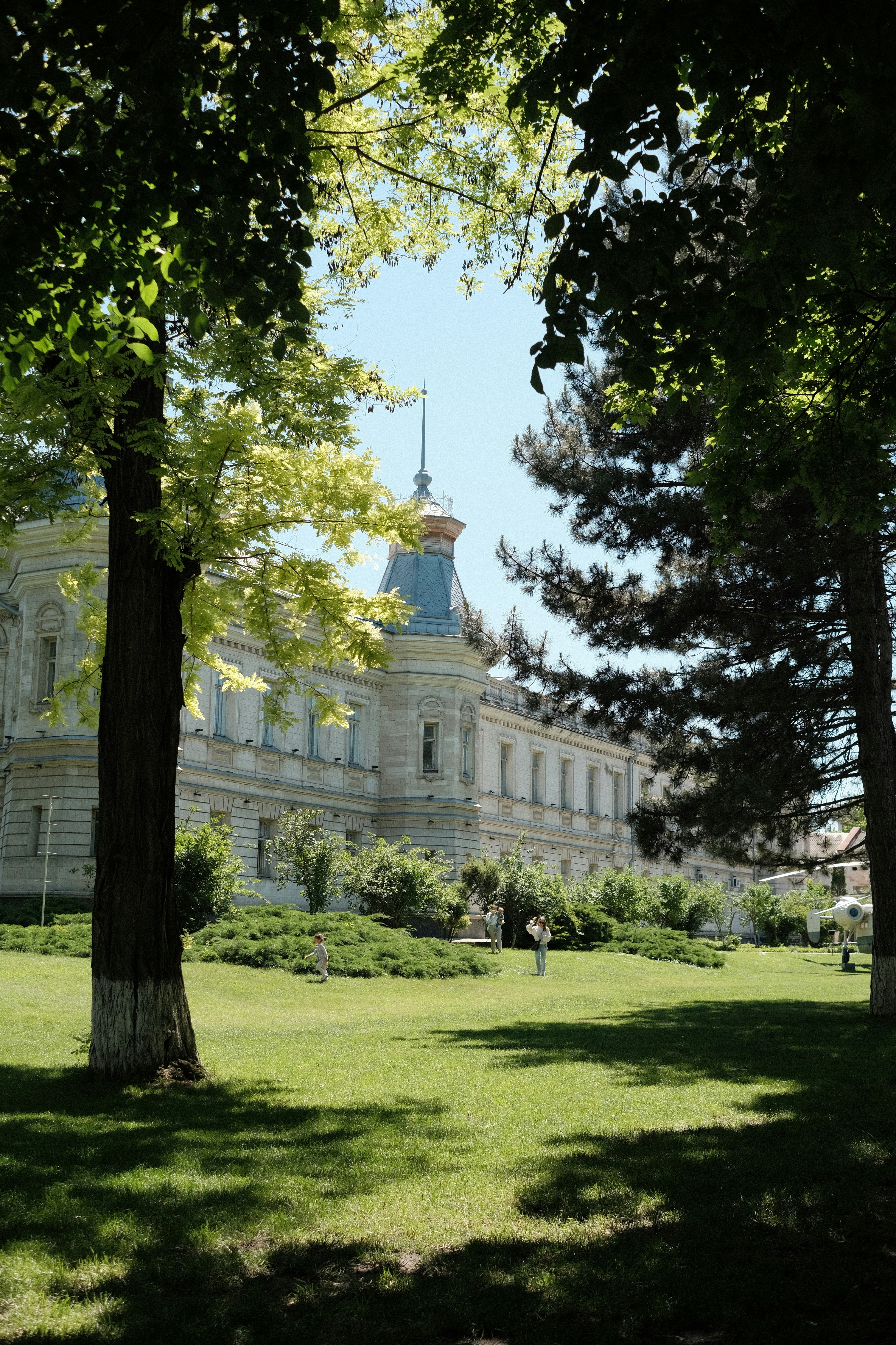 A beautiful building sits behind a green lawn.