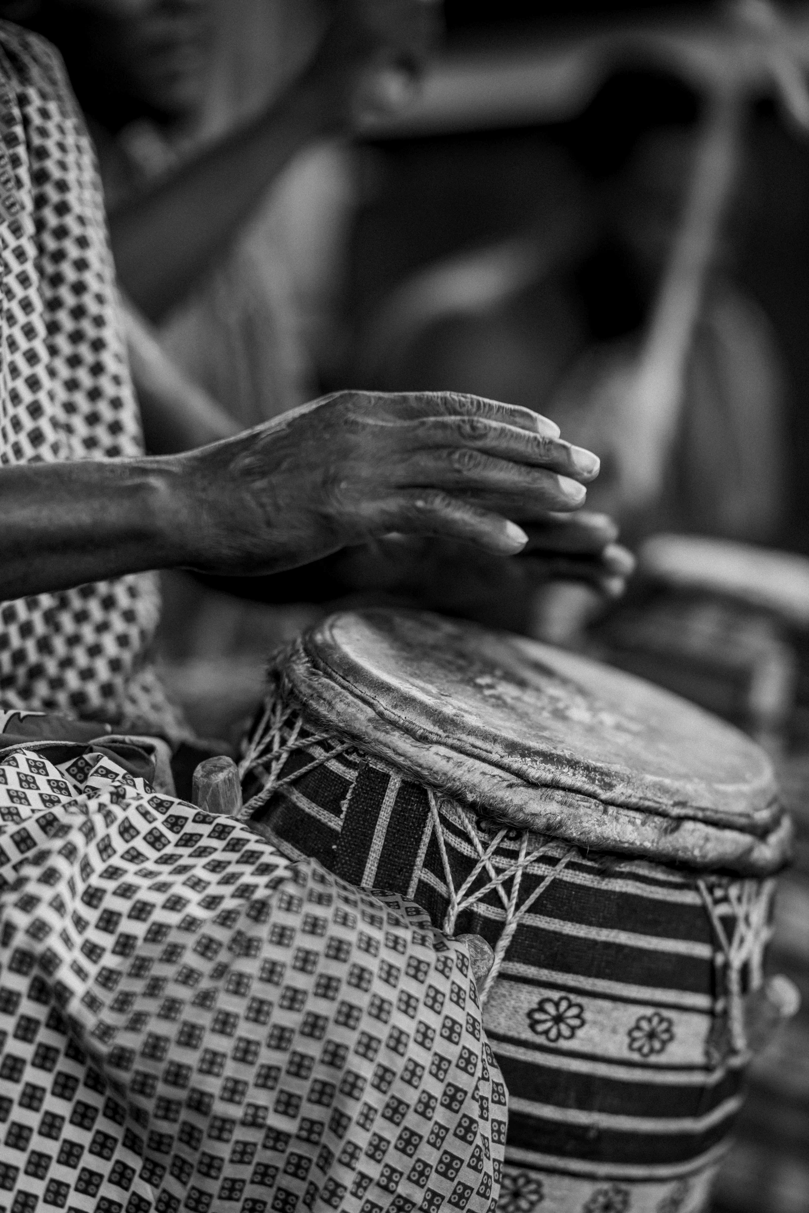 Hands striking a drum, photographed in black and white