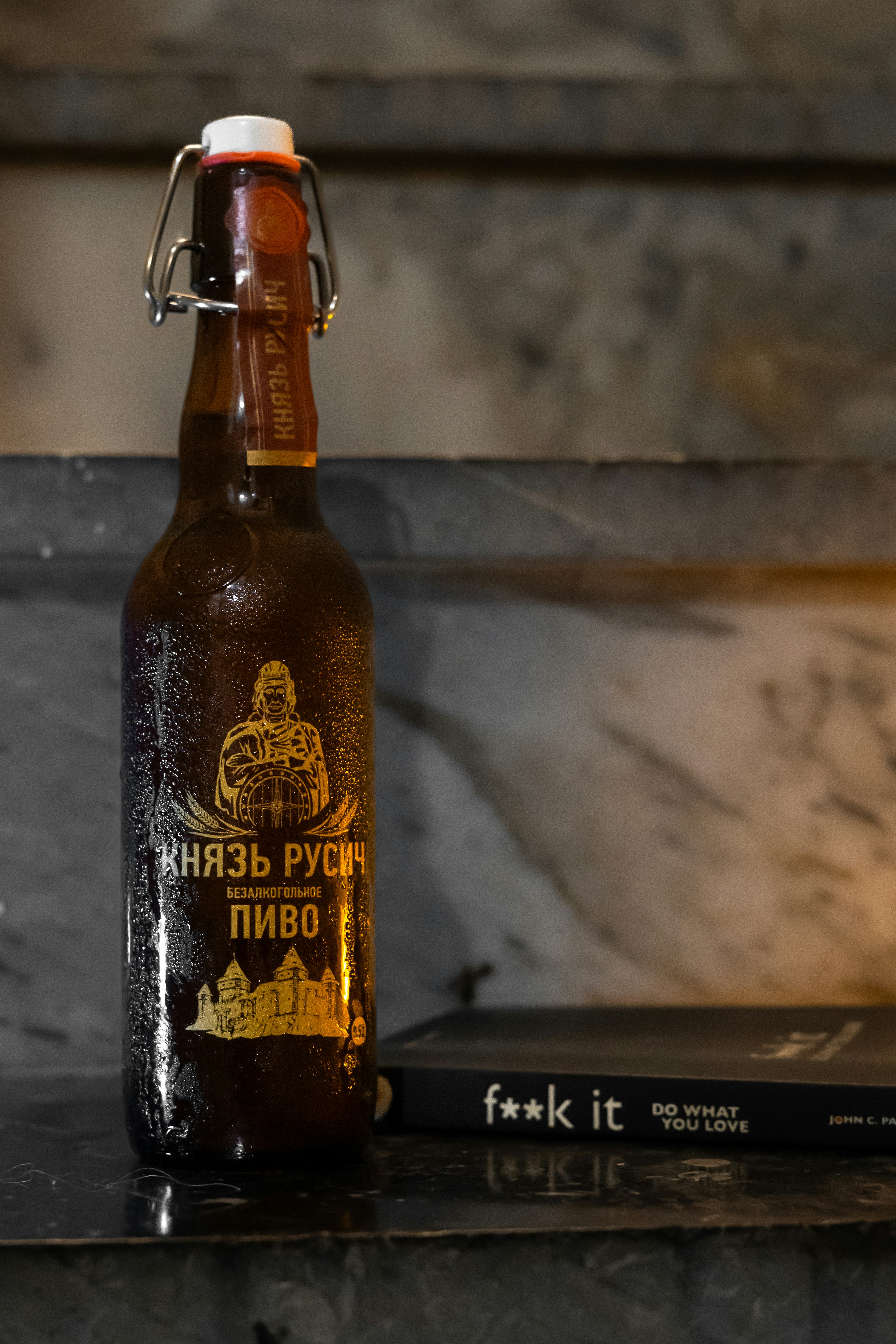A bottle of beer and a book on a staircase.