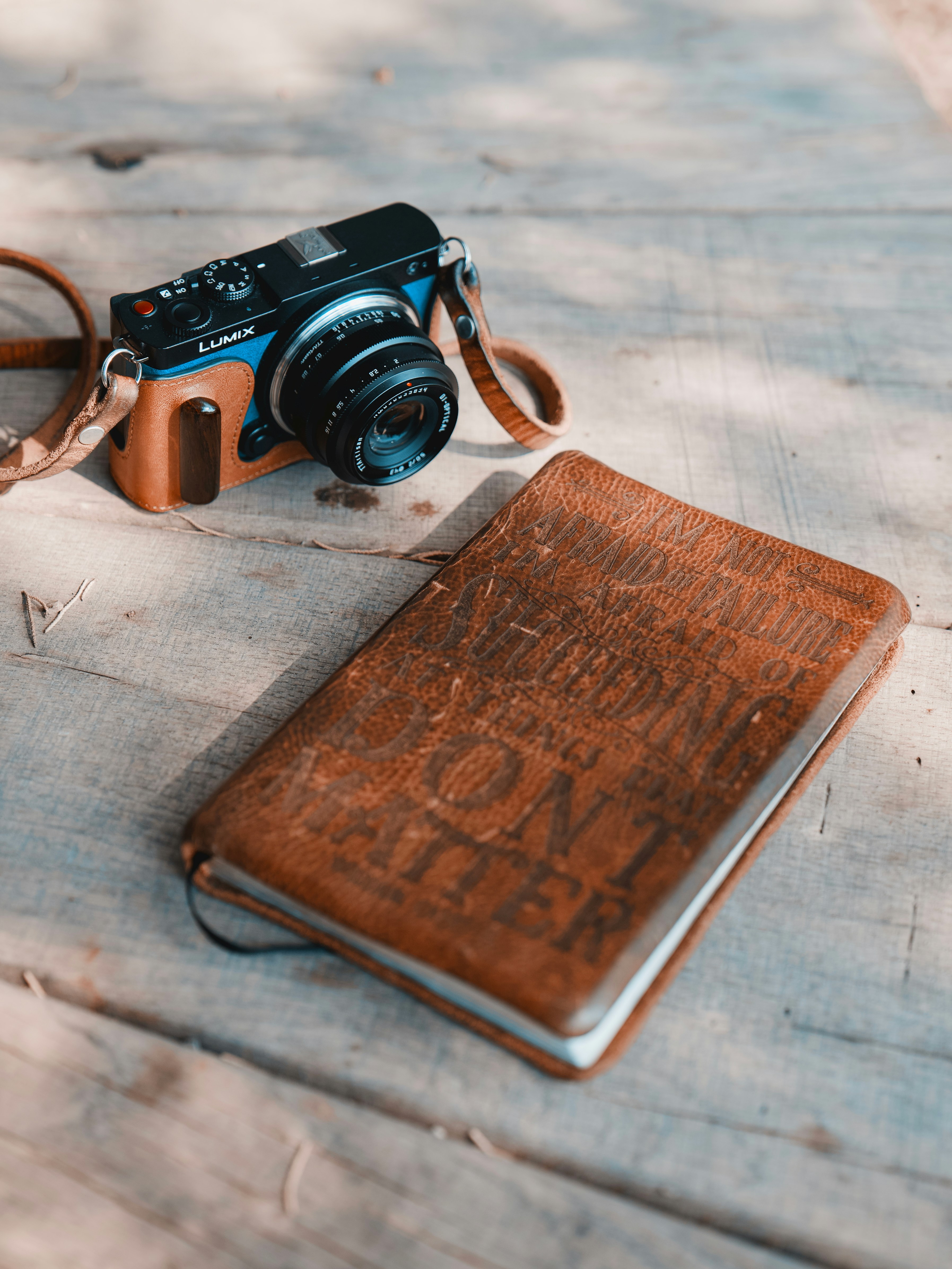 Camera and journal rest on a wooden surface.