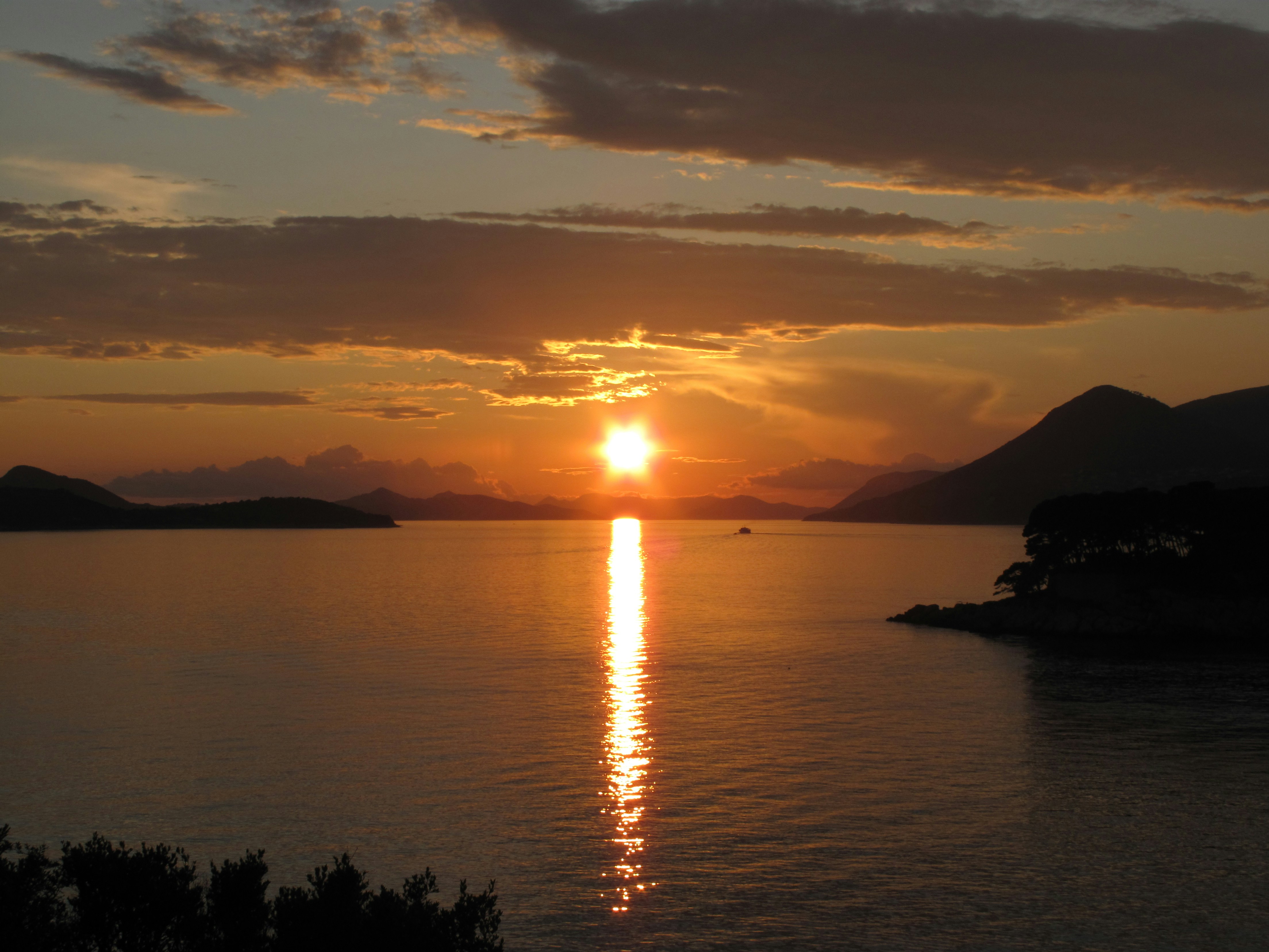 A golden sunset reflects on the calm water.