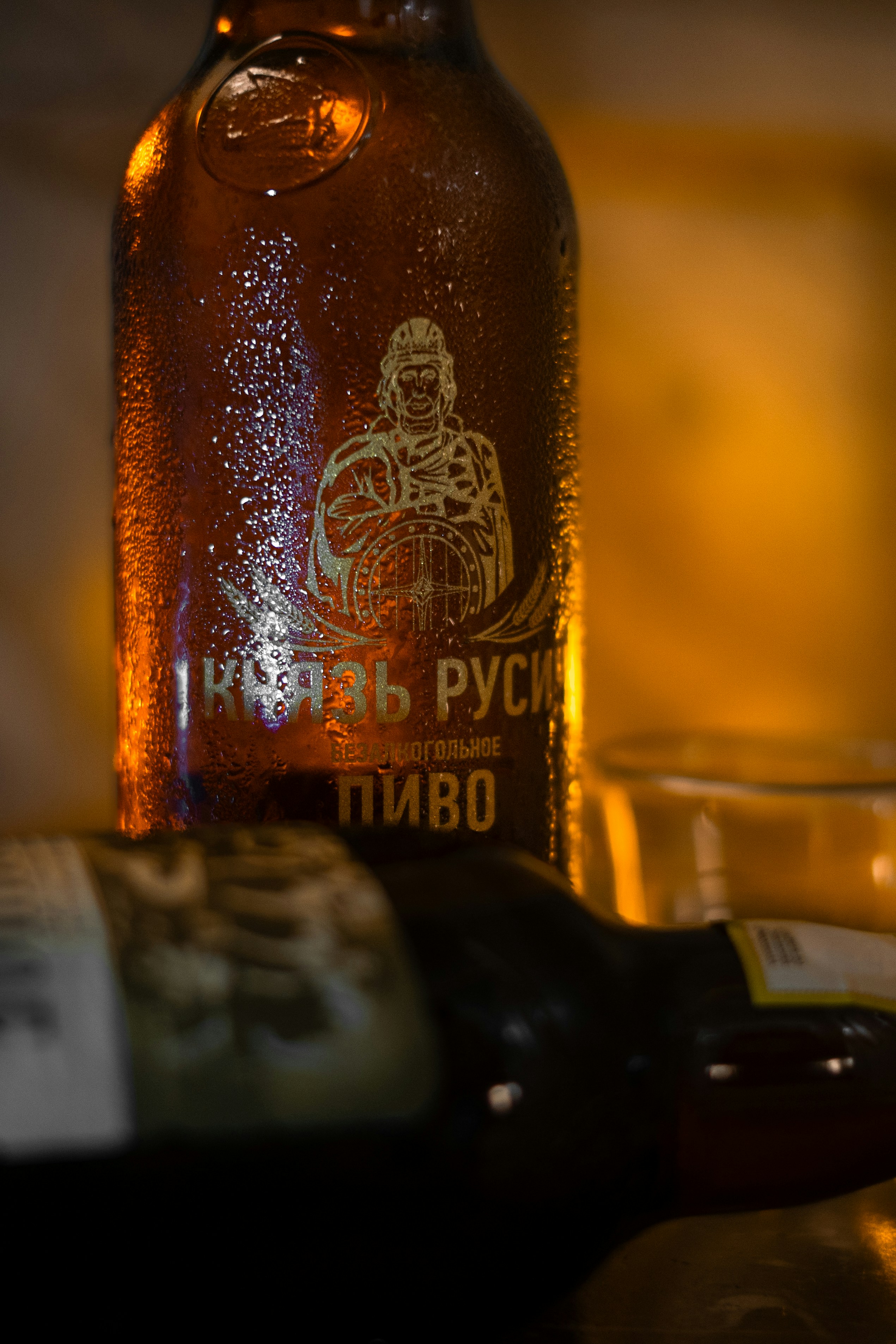 A bottle of beer with some condensation.