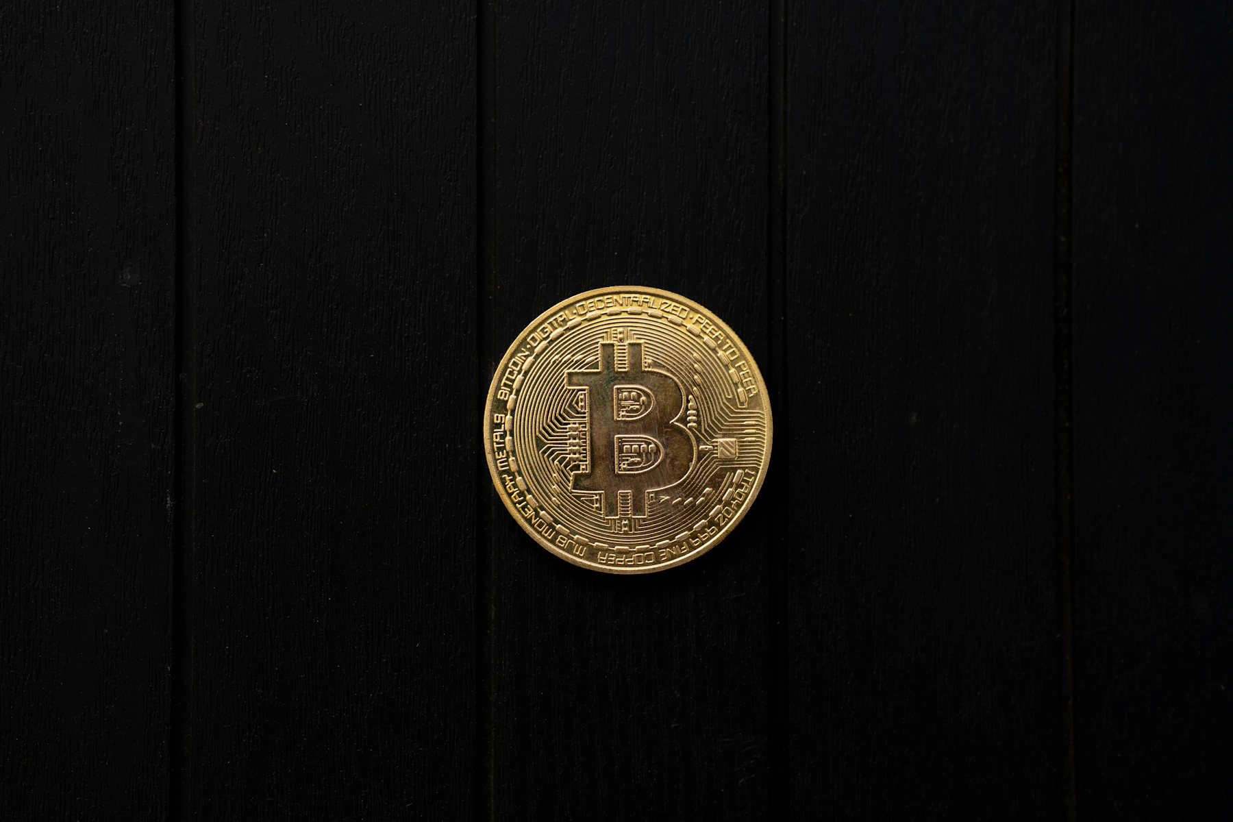 Moneda de Bitcoin dorada sobre fondo negro
