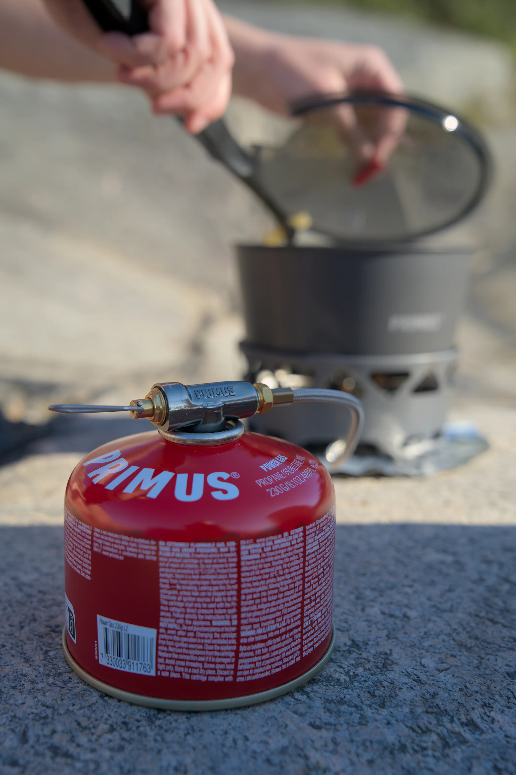 Portable camping stove and cookware being used outdoors
