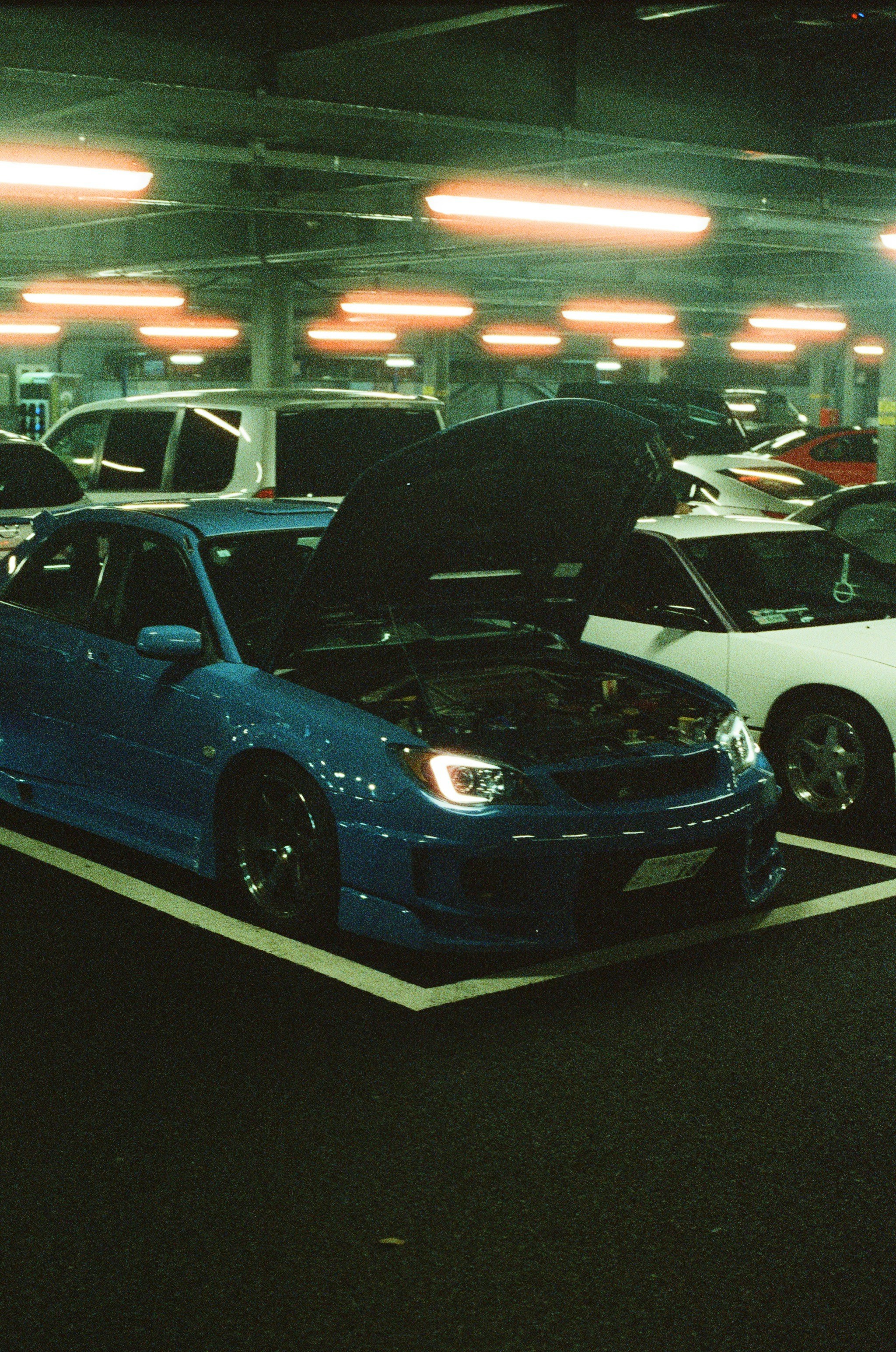 A blue car with its hood open.