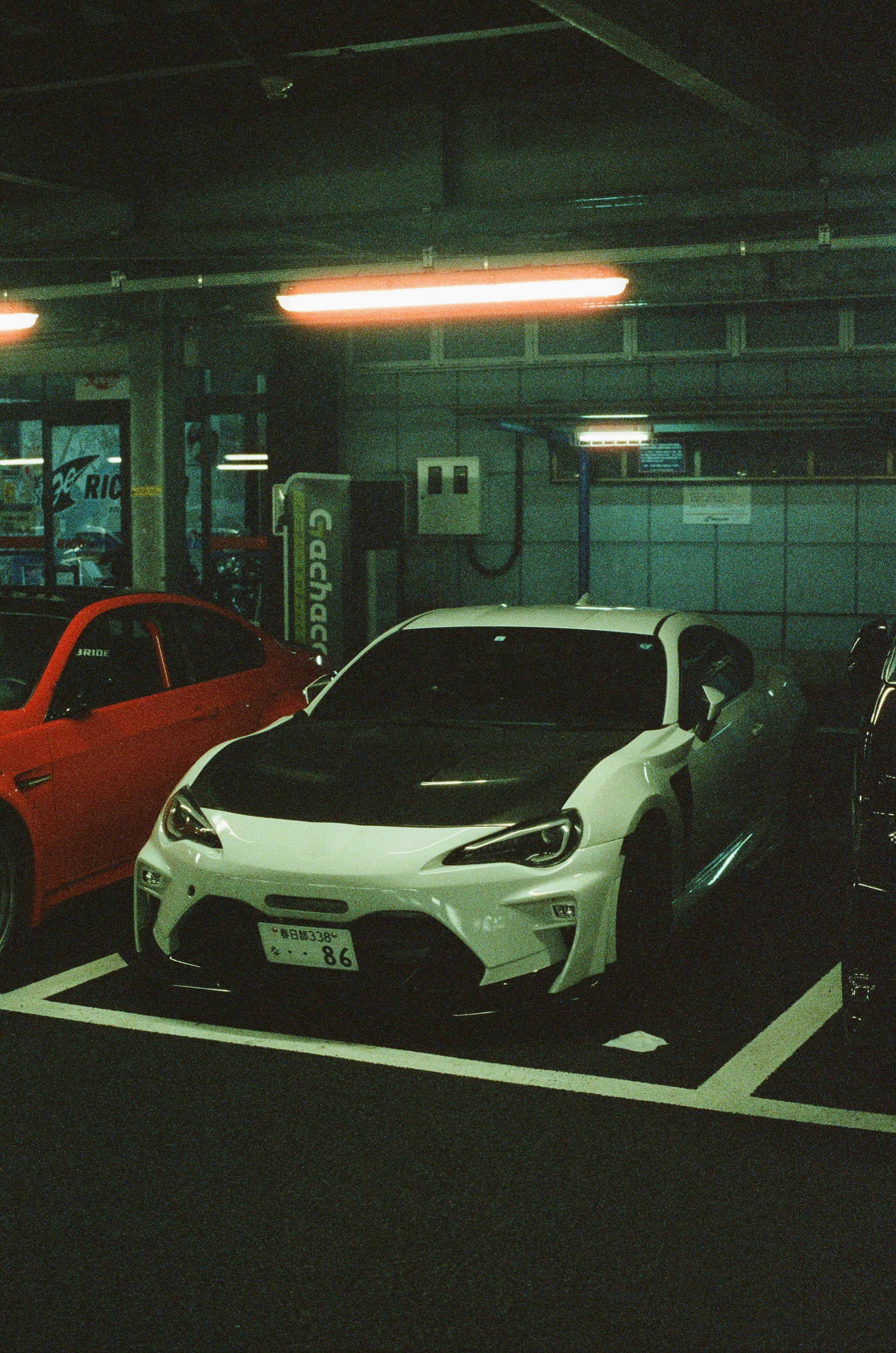 A white sports car is parked indoors.