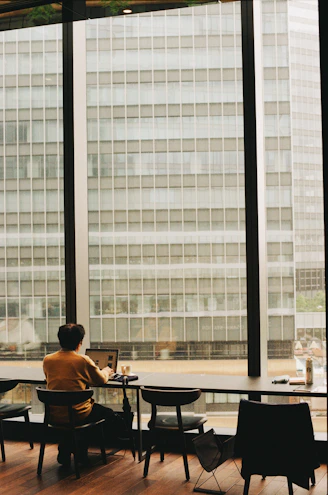 Person works at a desk overlooking tall buildings