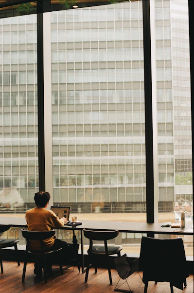 Person works at a desk overlooking tall buildings