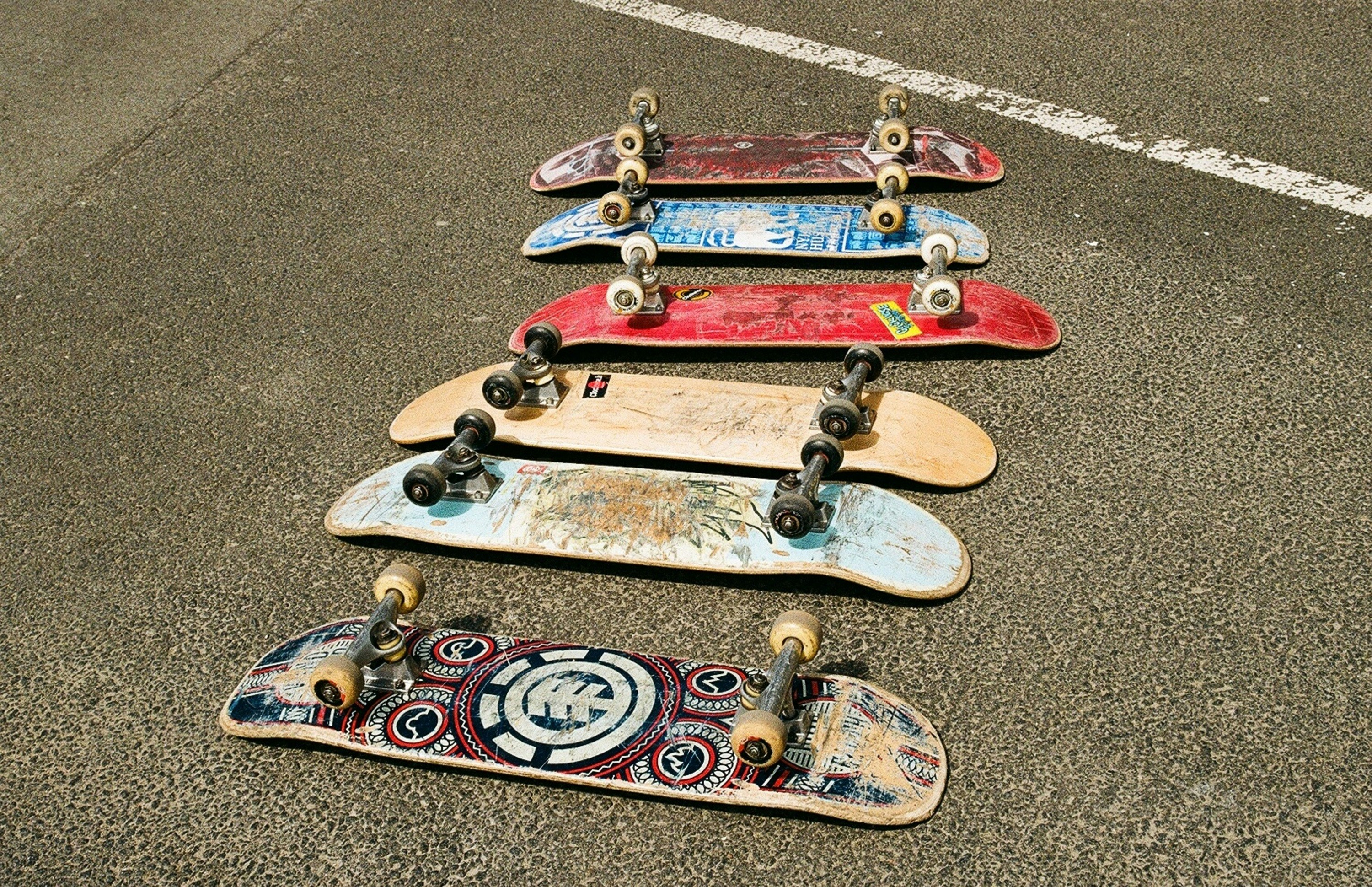 Several skateboards are lined up on the ground.