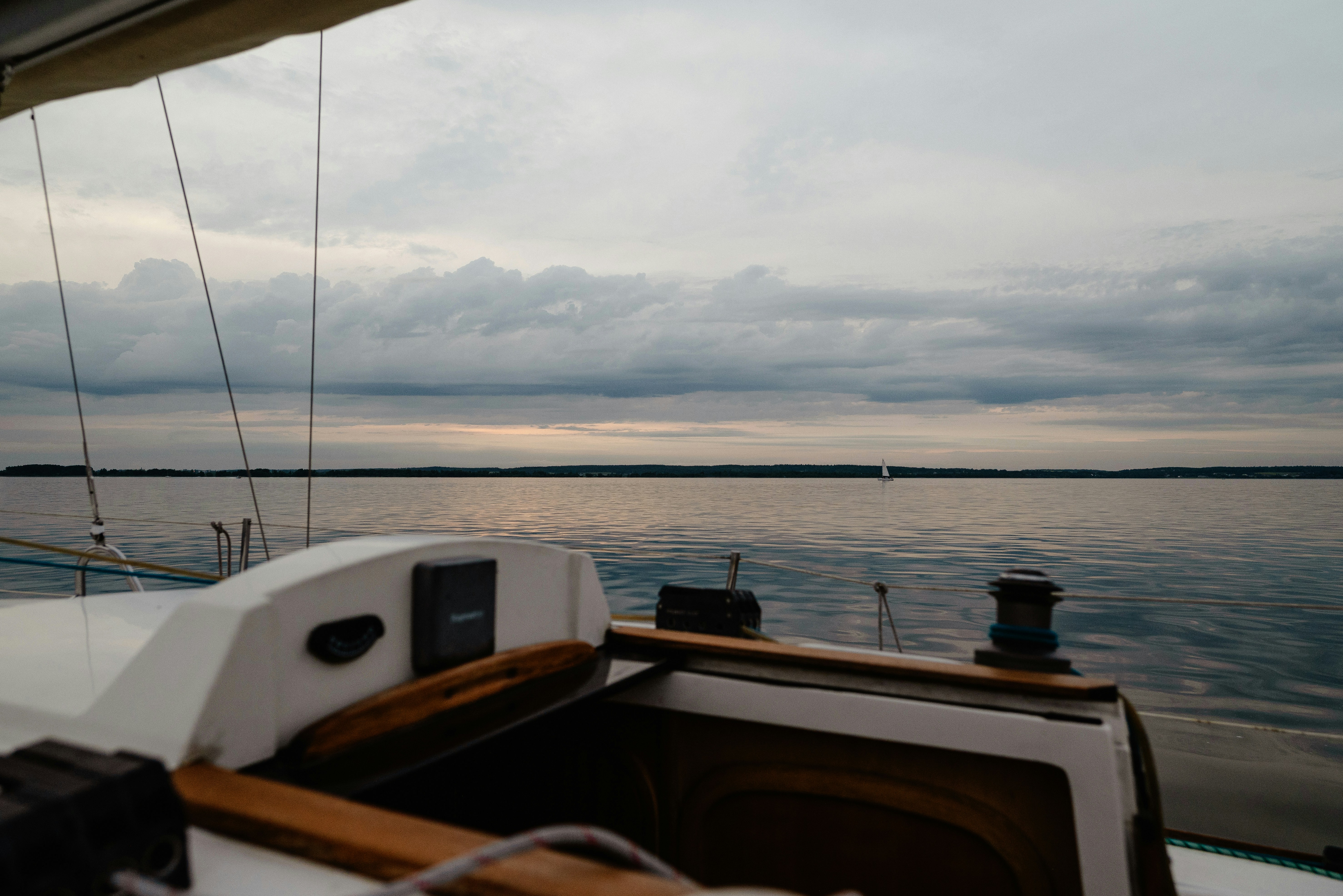 View from a sailboat overlooking calm waters.