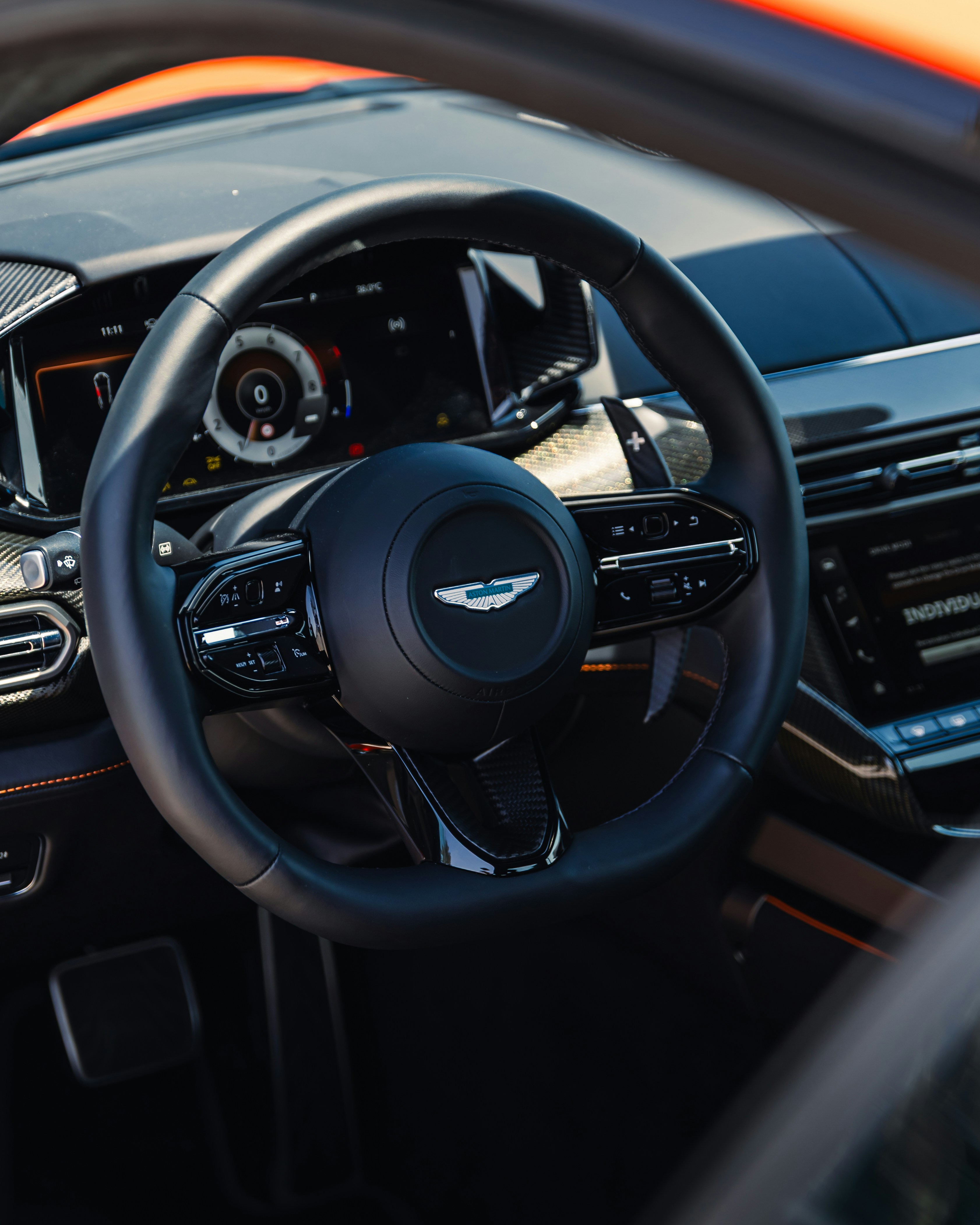 Here is a possible caption: **aston martin's steering wheel and dashboard are displayed.**
