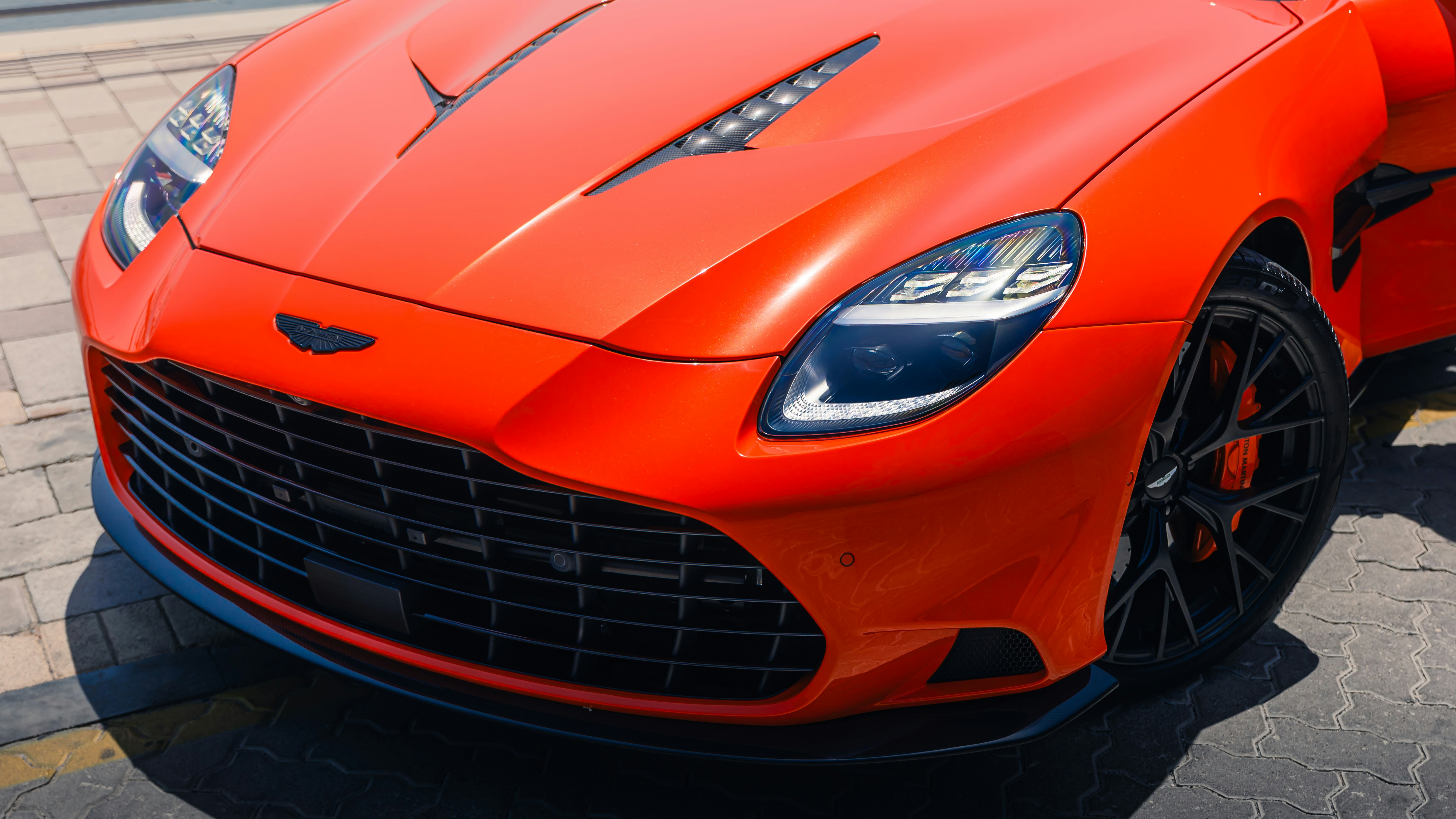 Here's a caption: an orange sports car's front end is shown.