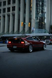 A red sports car drives through a city street.