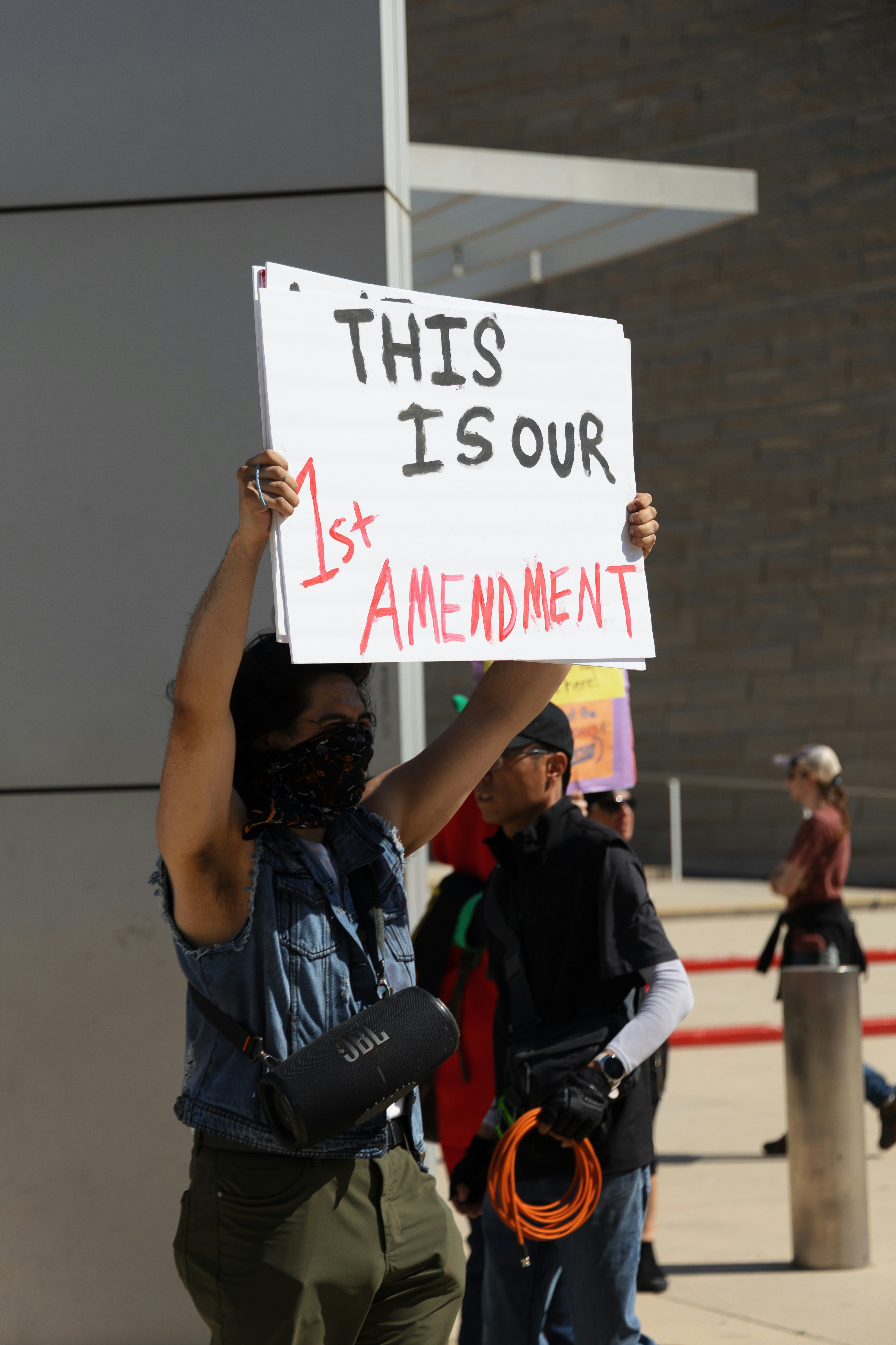 Protester holds a sign, referencing the first amendment.