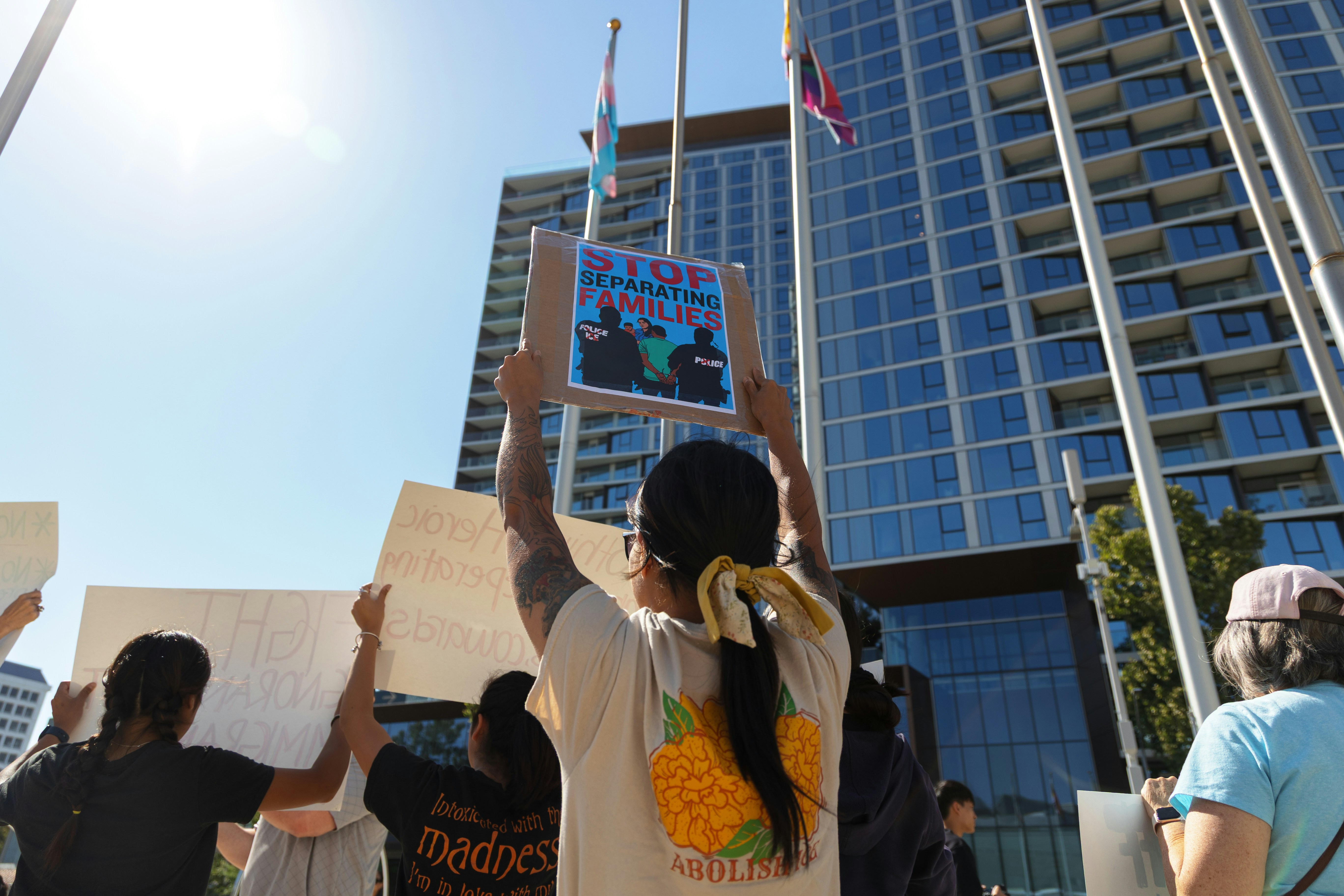 Menschen protestieren mit Schildern vor einem Gebäude.