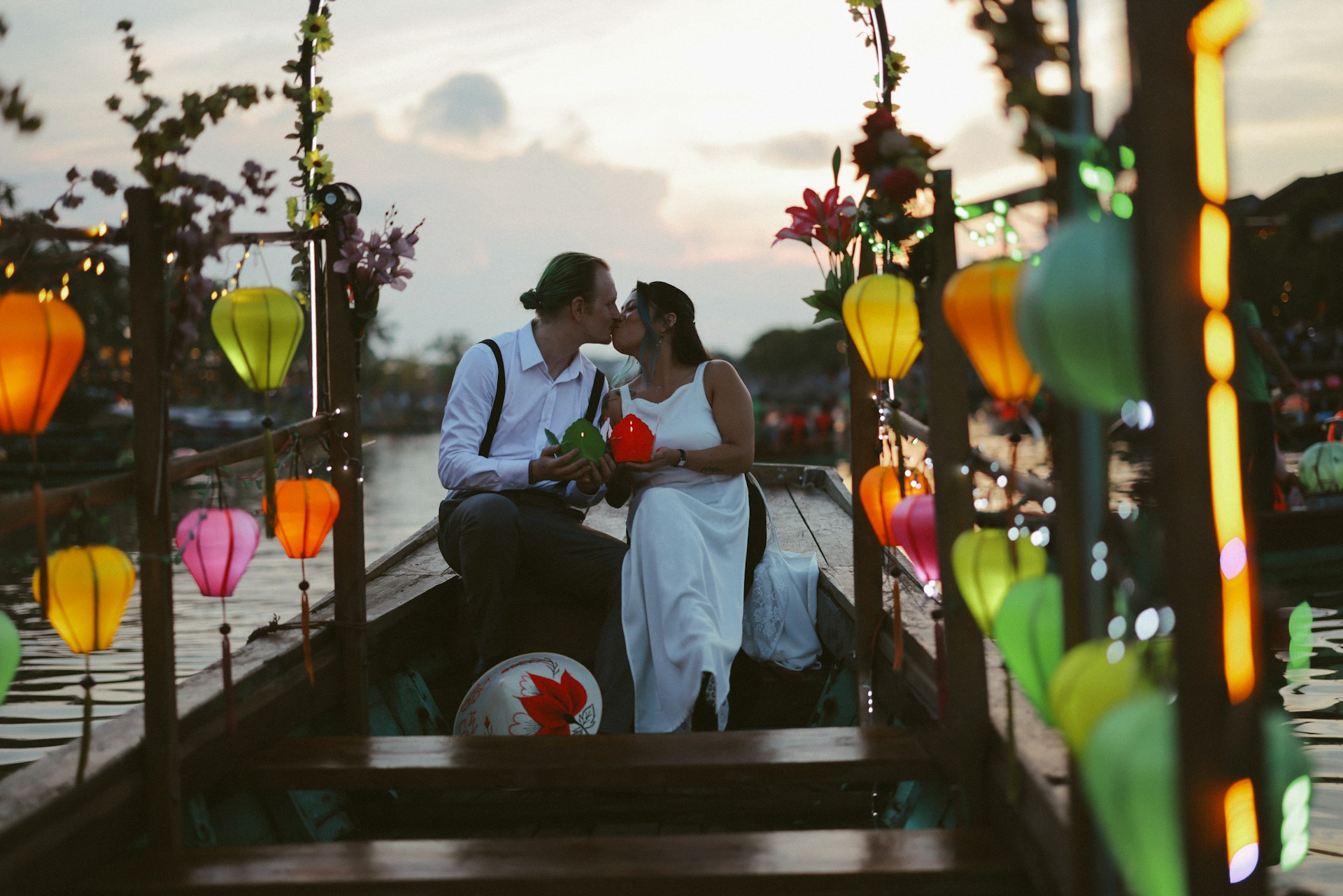 A newlywed couple shares a kiss on a boat.