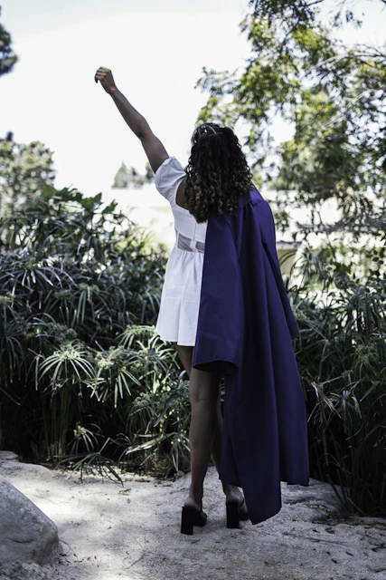 Celebrating graduation, she raises her arm high
