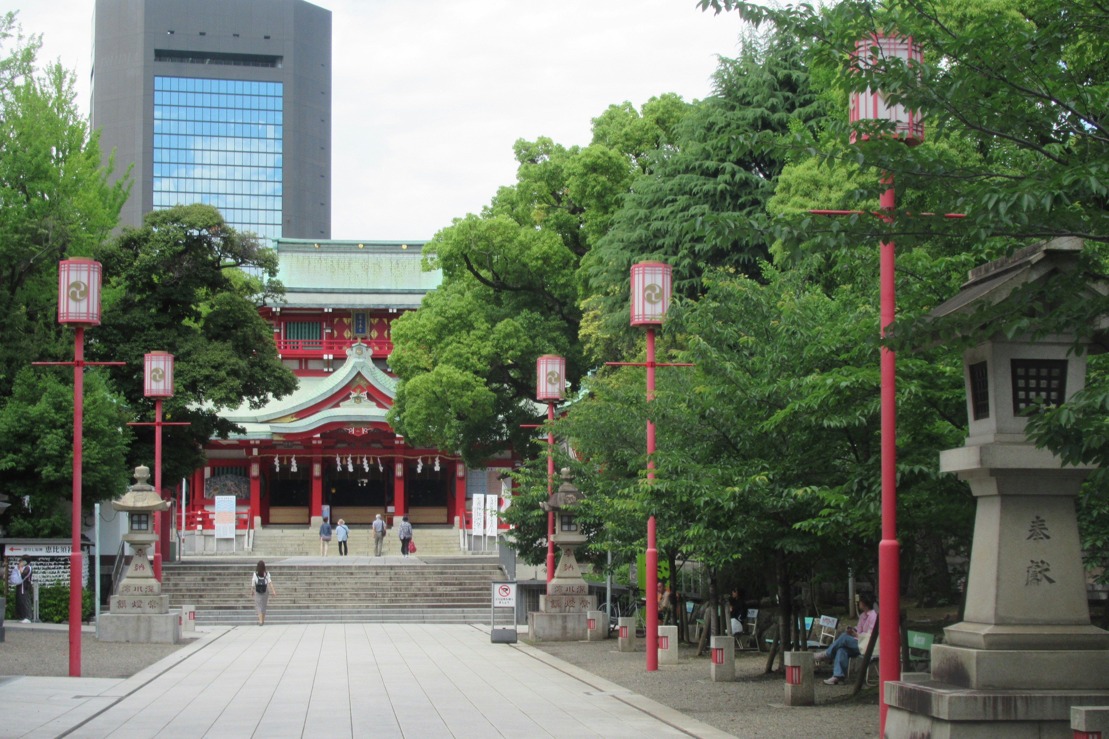 A japanese temple sits amidst trees and lanterns. - Koyasan