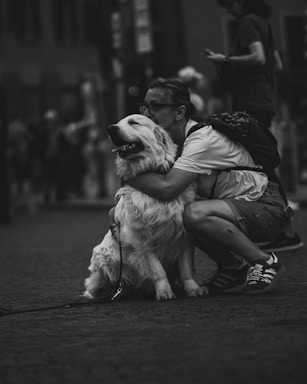 A man hugs and kisses a big, fluffy dog.