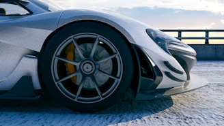 Sleek, silver sports car shows off its wheel.