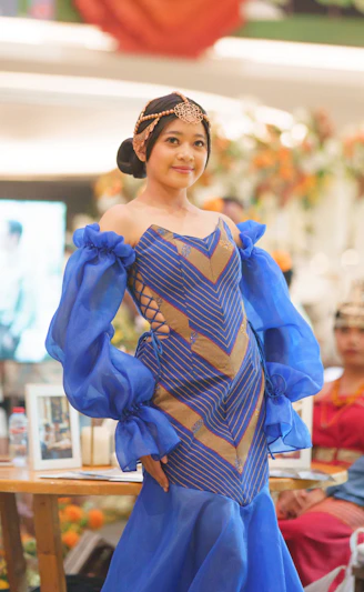 A young woman models a blue and gold gown.