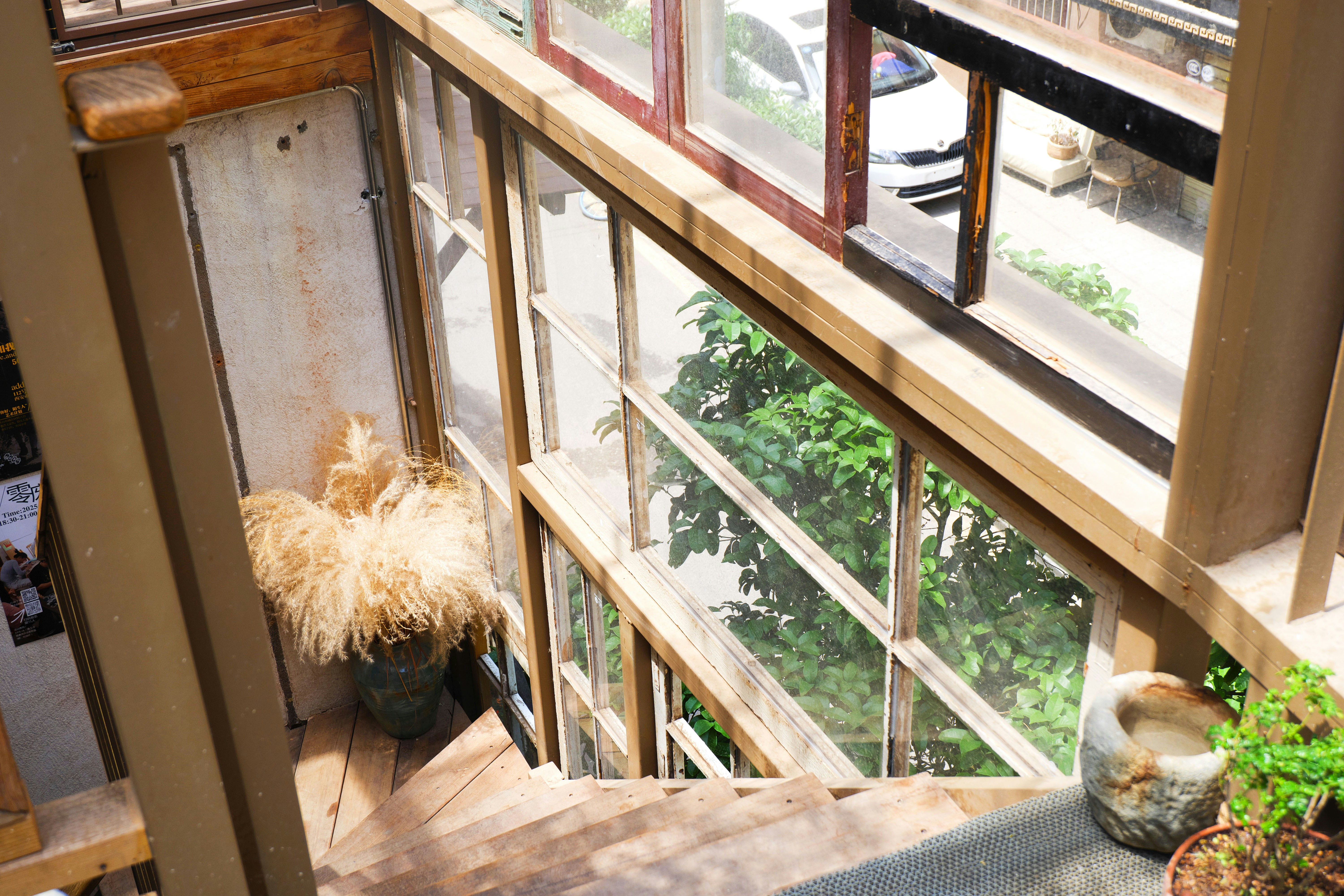 Looking down a wooden staircase with windows.