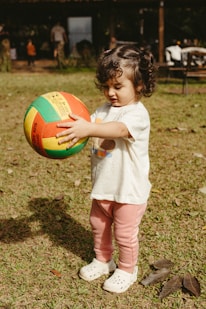 A child holds a colorful ball.