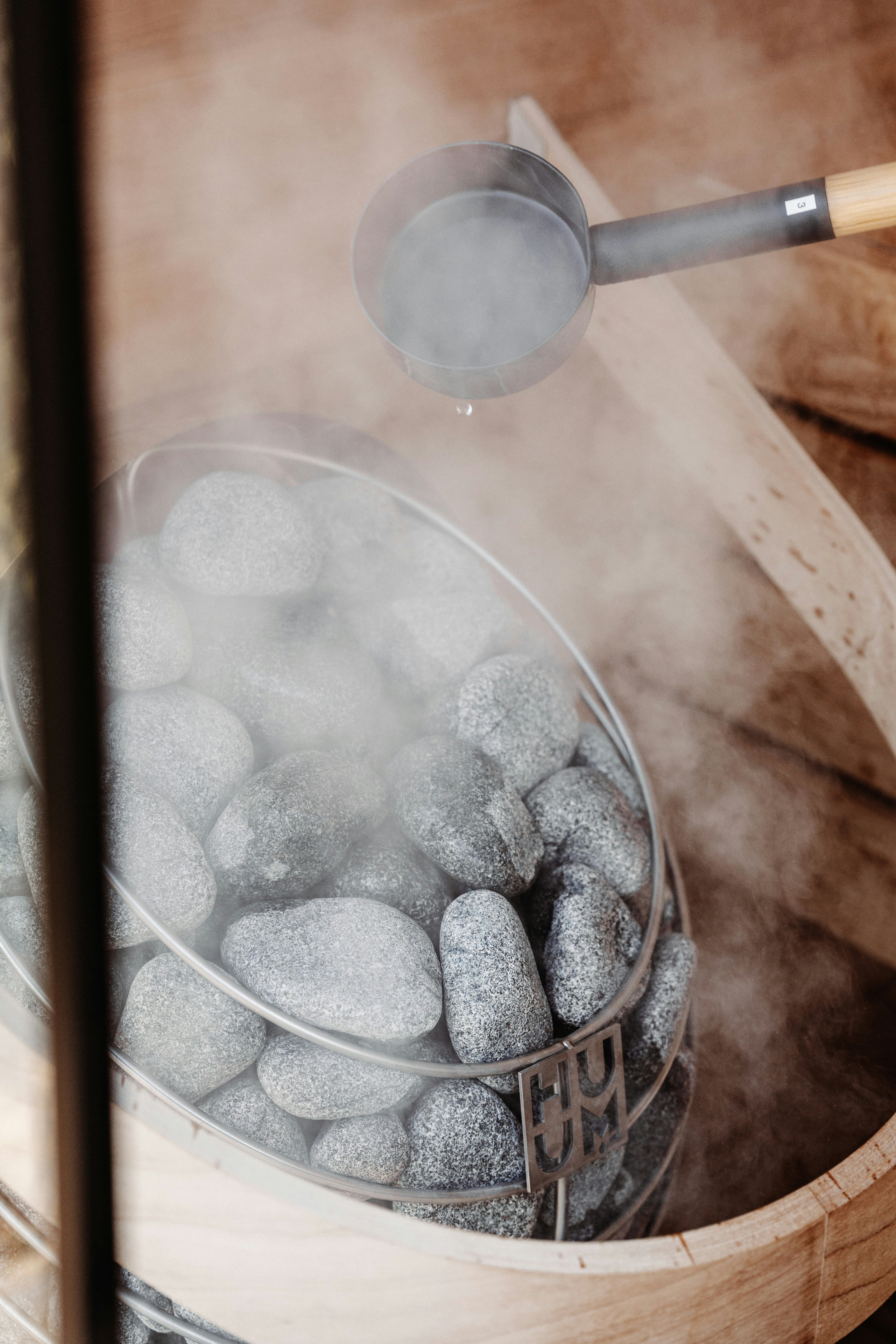 Water is being poured onto hot sauna rocks.