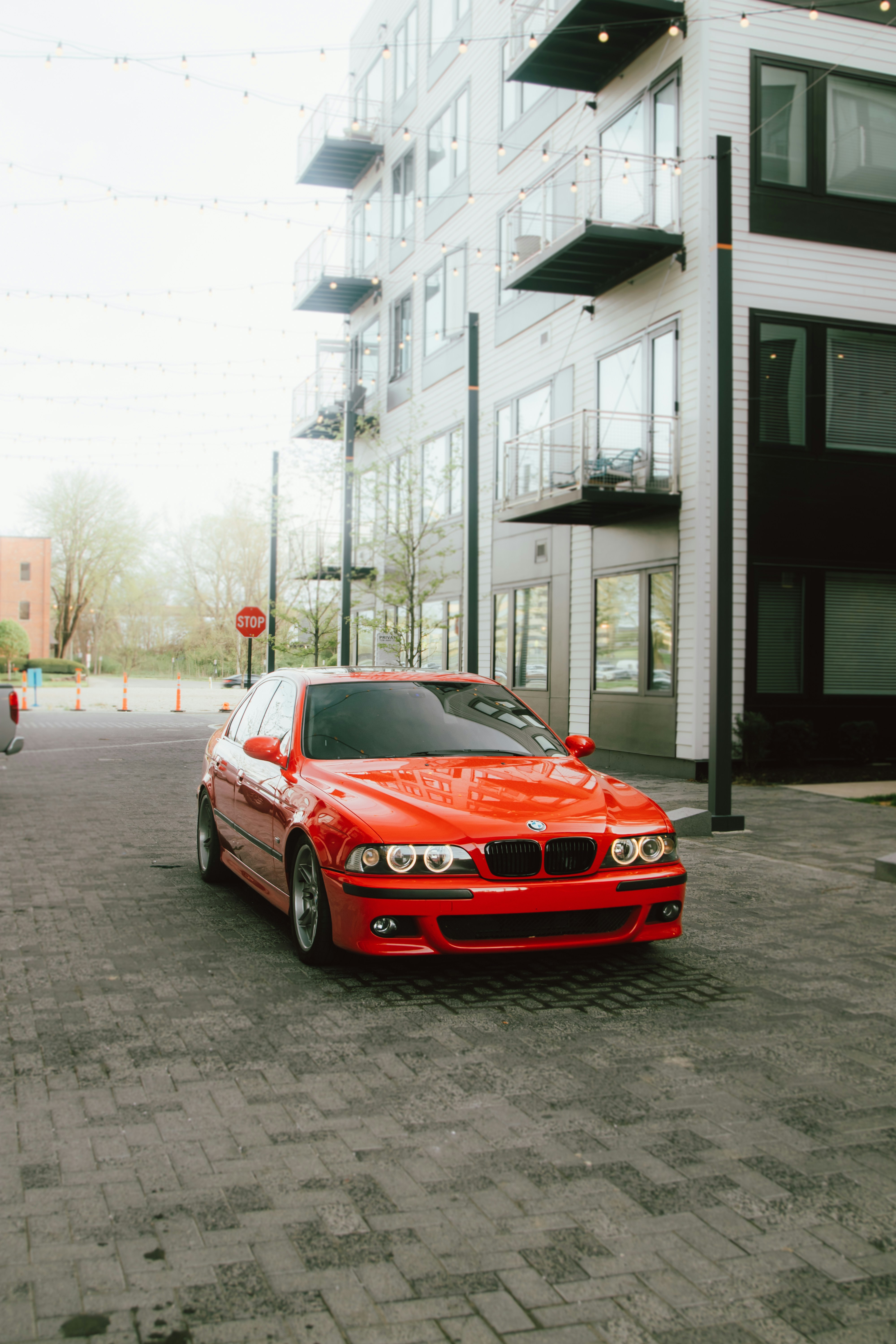 Red car parked near a modern, white building.