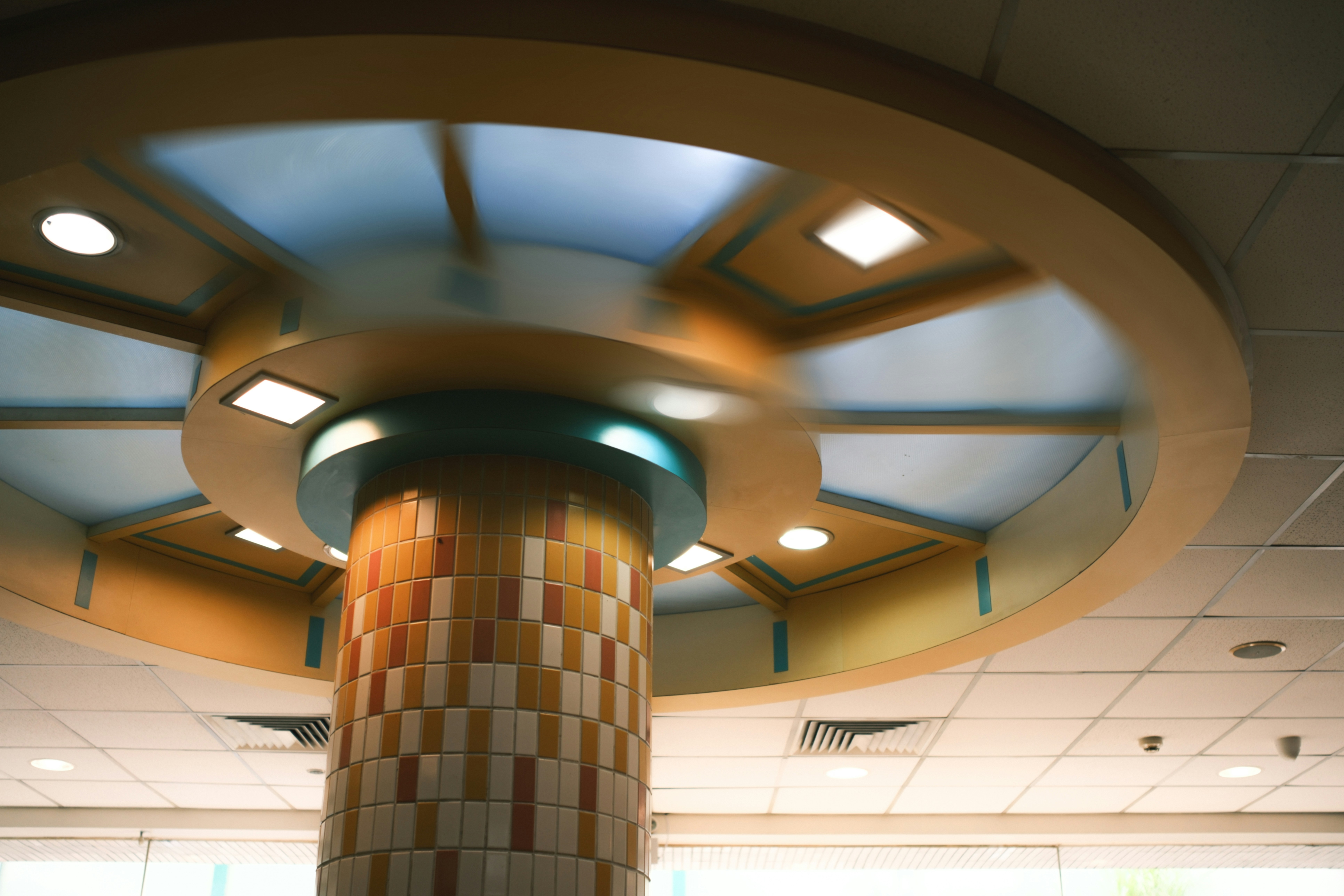 An ornate ceiling design surrounds a decorative column.