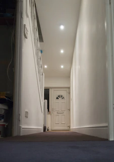 A hallway leads to a white front door.