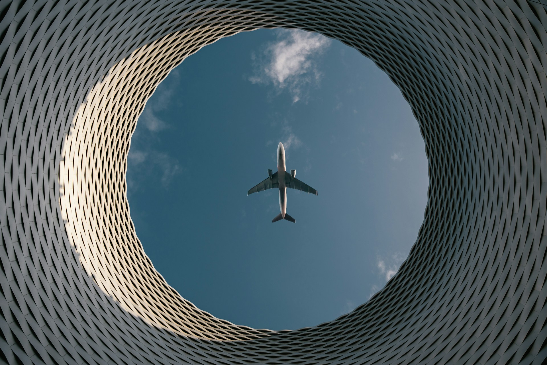 An airplane flies through a circular opening.