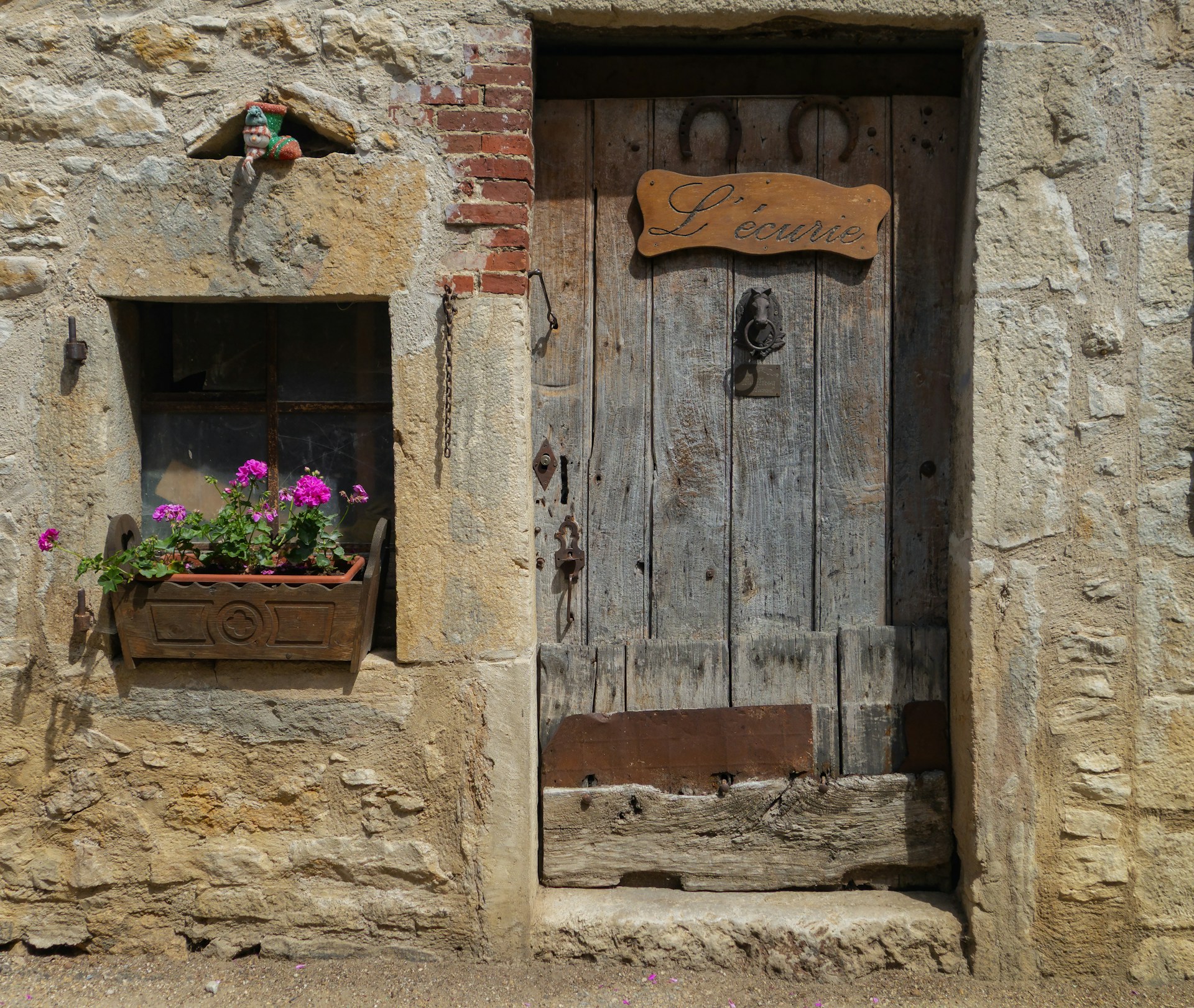 An old, rustic door with a floral window box.