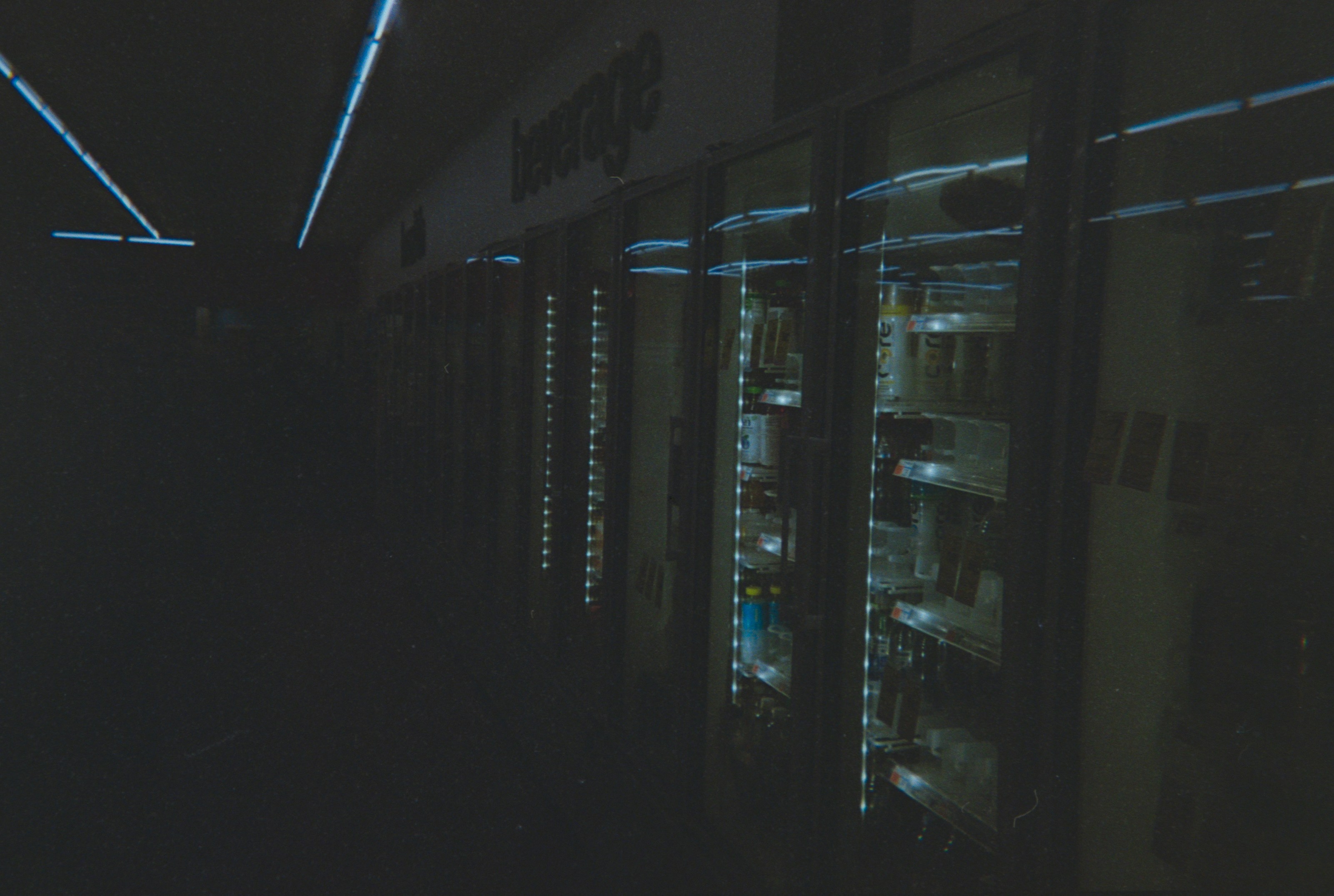 Empty shelves are dimly lit in a store.