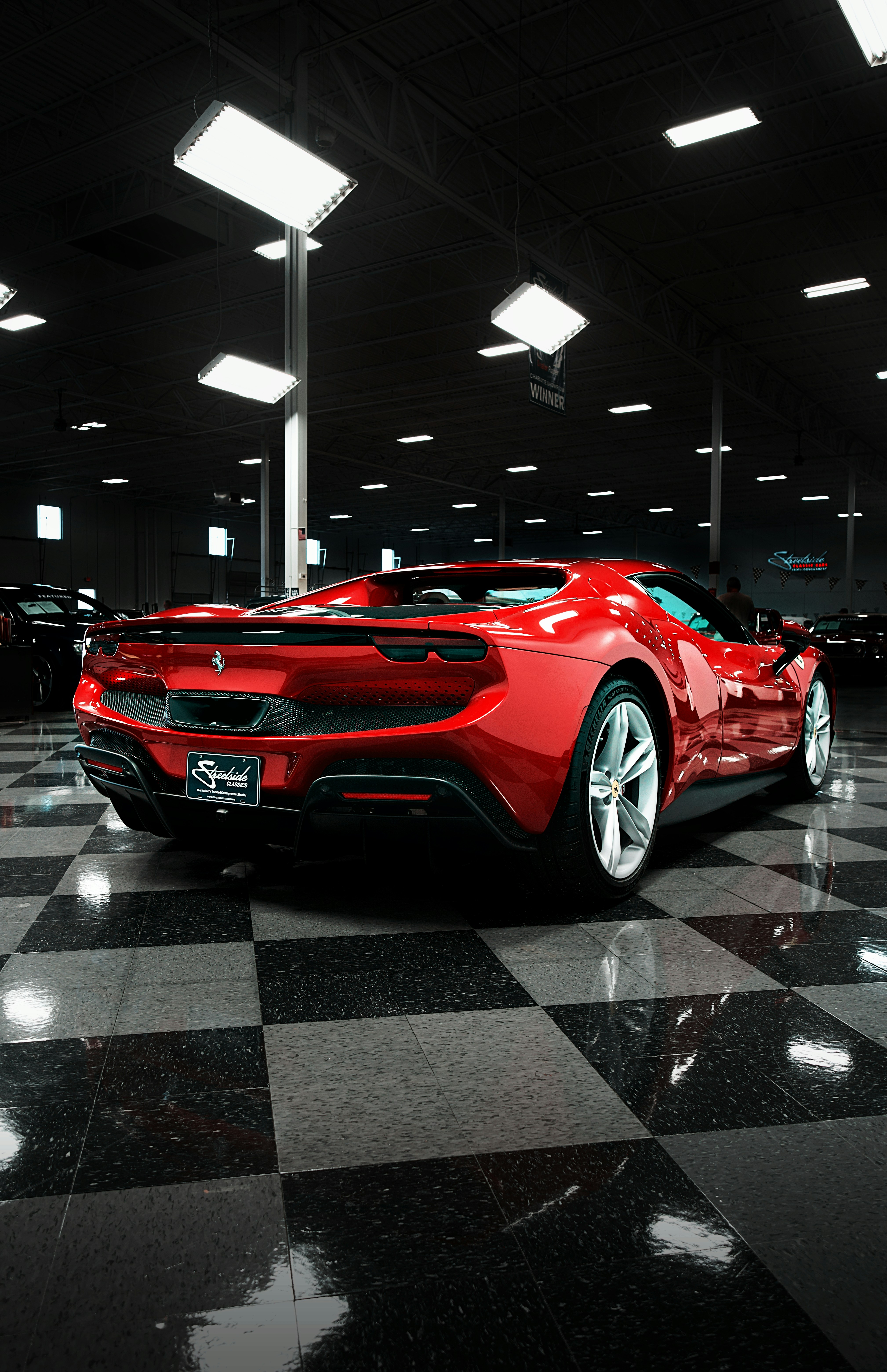 A red ferrari sits in a showroom.